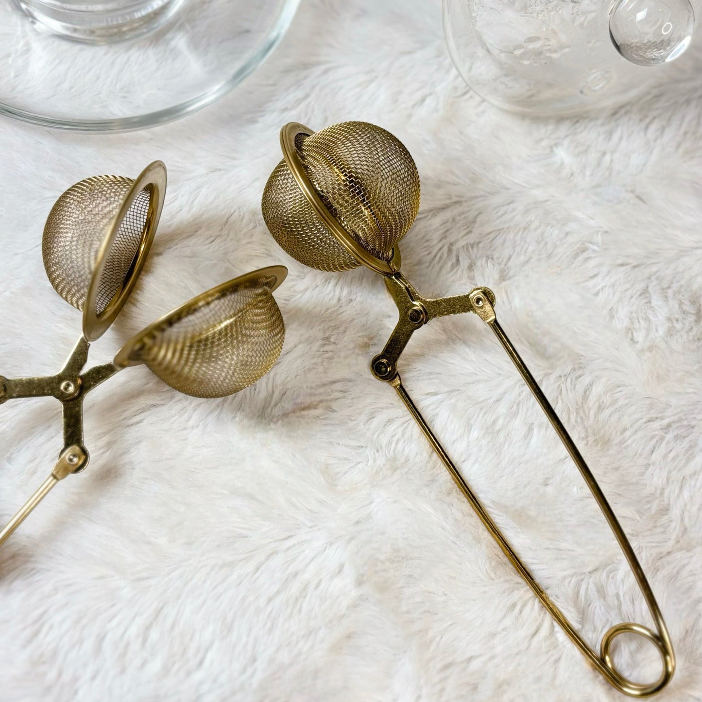 Gold tea infuser on a white background