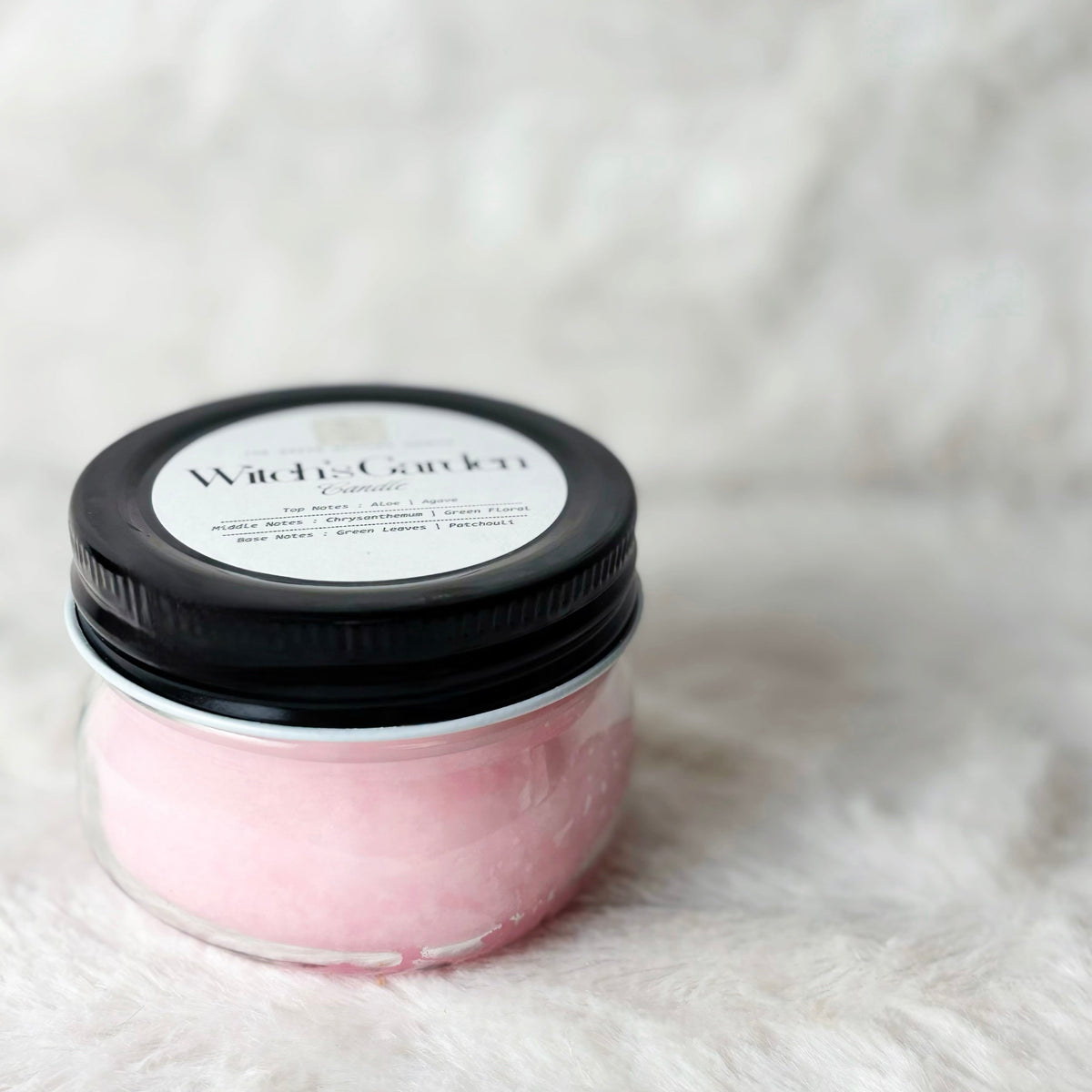 Pink jar with black lid on a white background