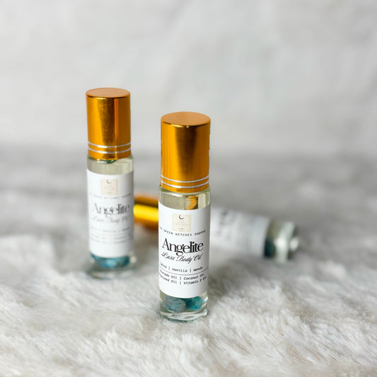 Two small bottles of Angelite Clean Body Oil on a textured surface with a neutral background