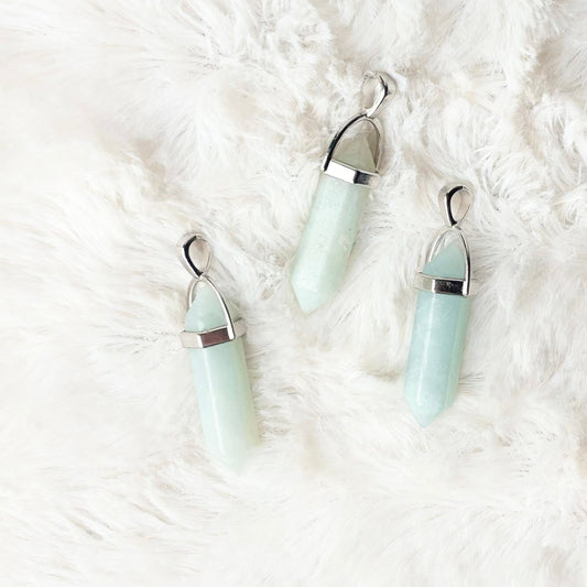 Three light blue earrings on a white fluffy surface