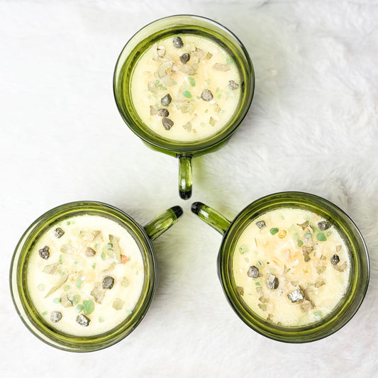 Candles with stones in a green glass cup
