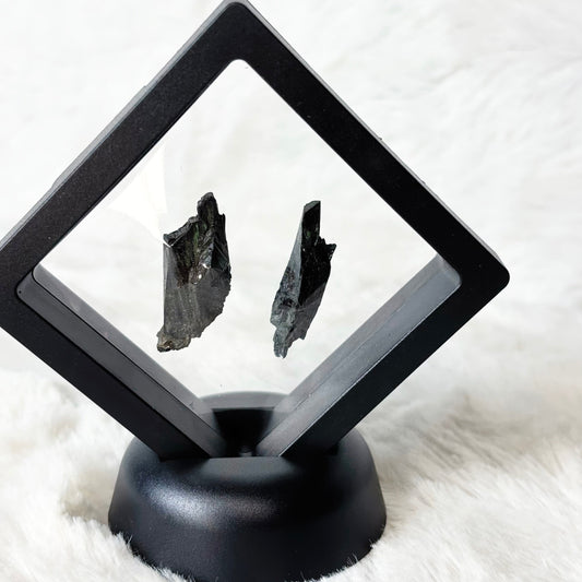 Framed Vivianite specimens on a white background