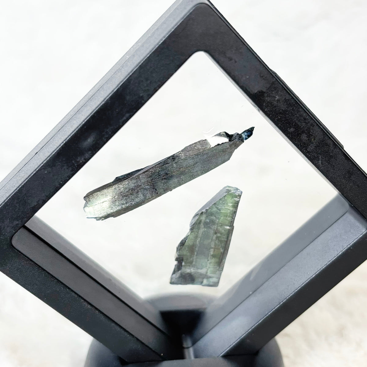 Framed Vivianite specimens on a white background