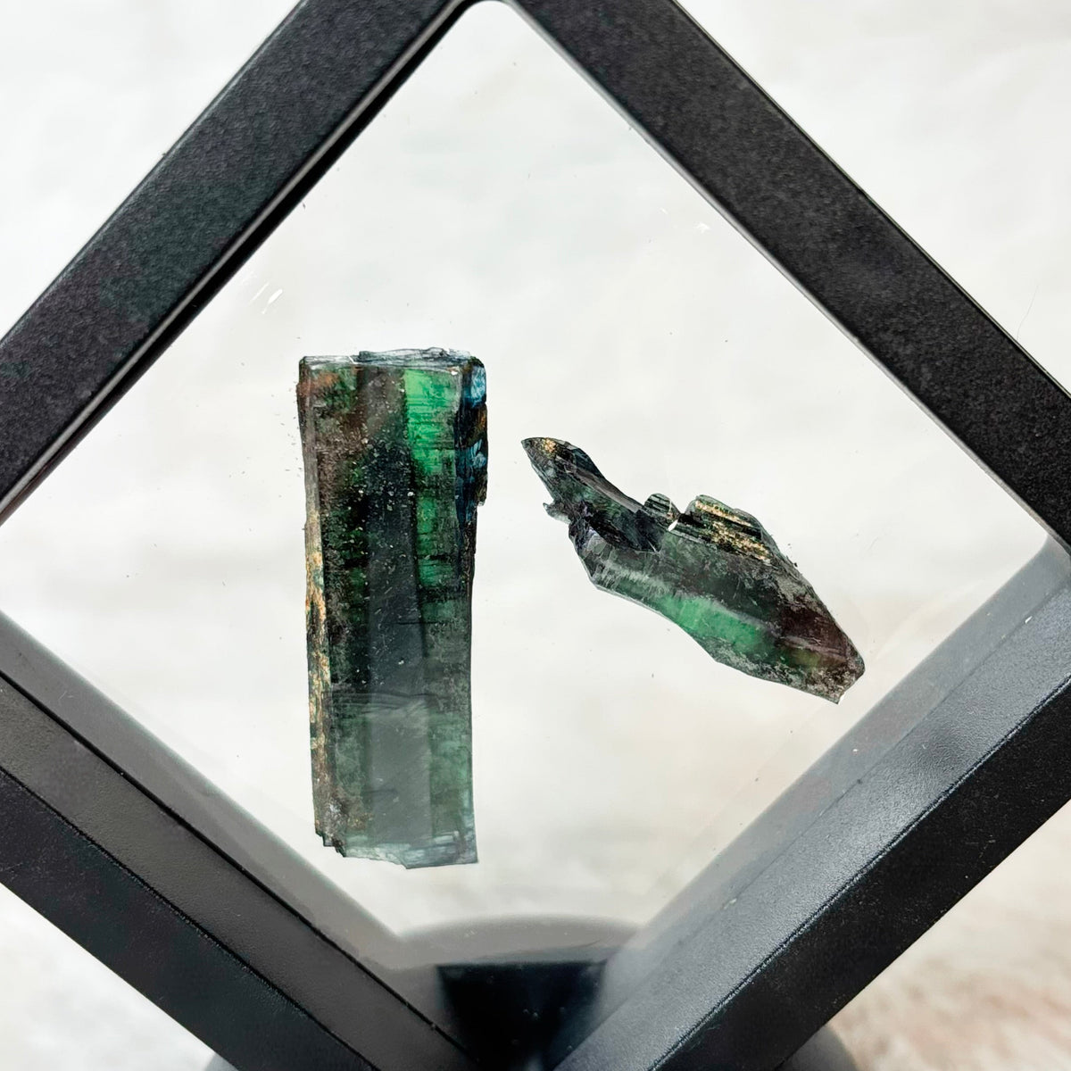 Framed Vivianite specimens on a white background