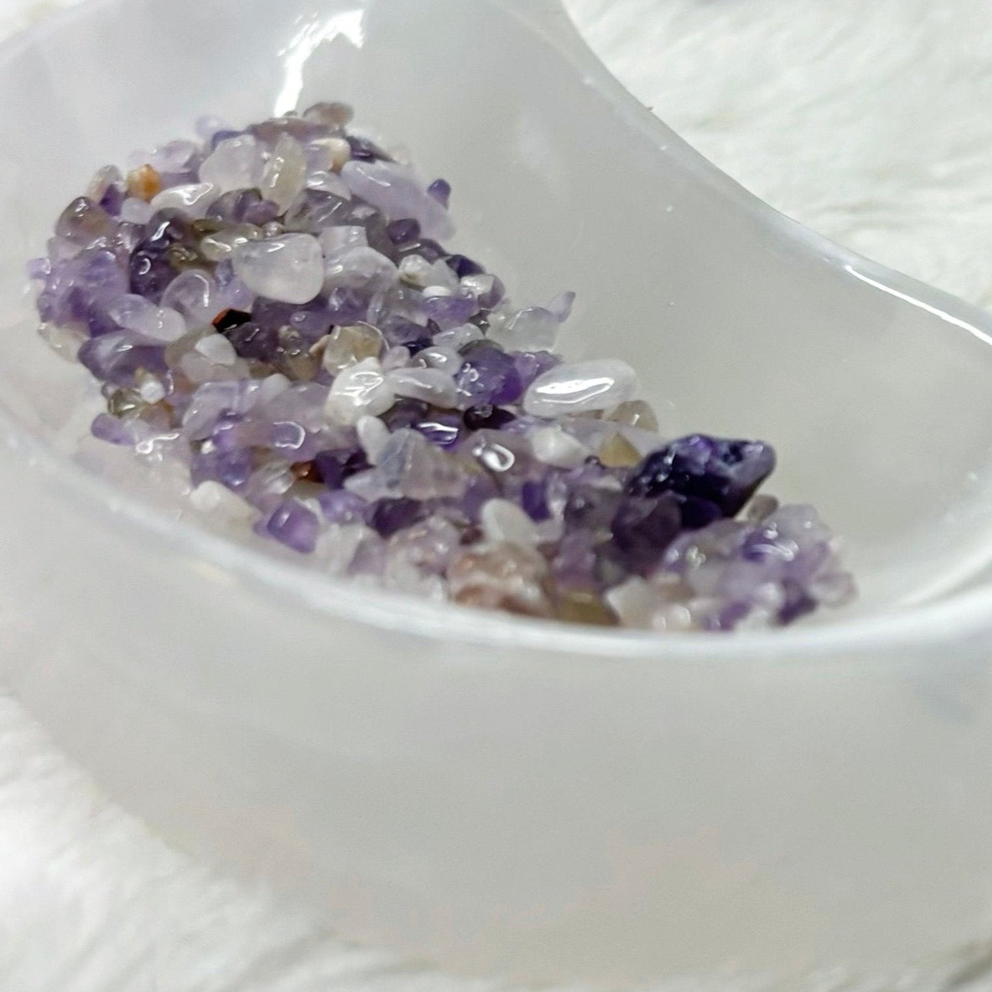 Amethyst crystals in a white dish with labeled bottles in the background