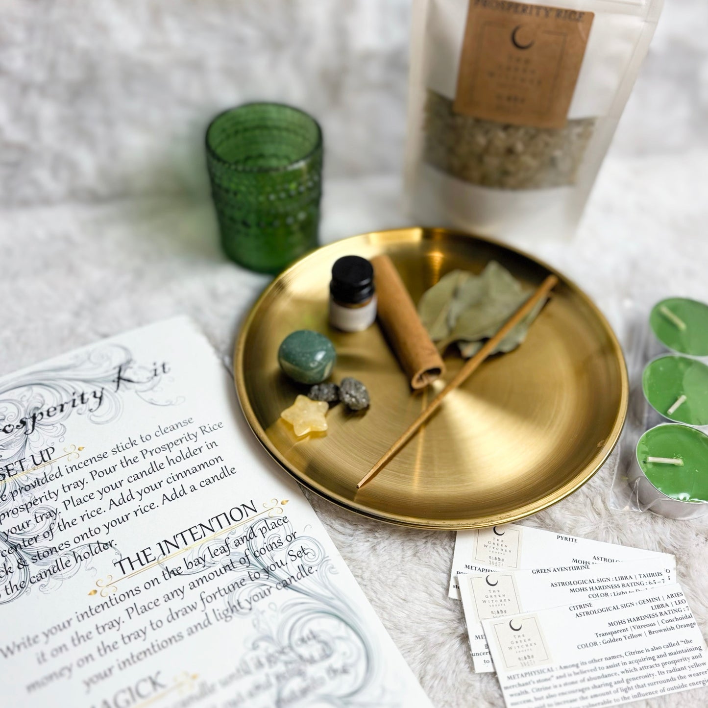 Decorative setup with a gold tray, candles, and incense on a textured surface.