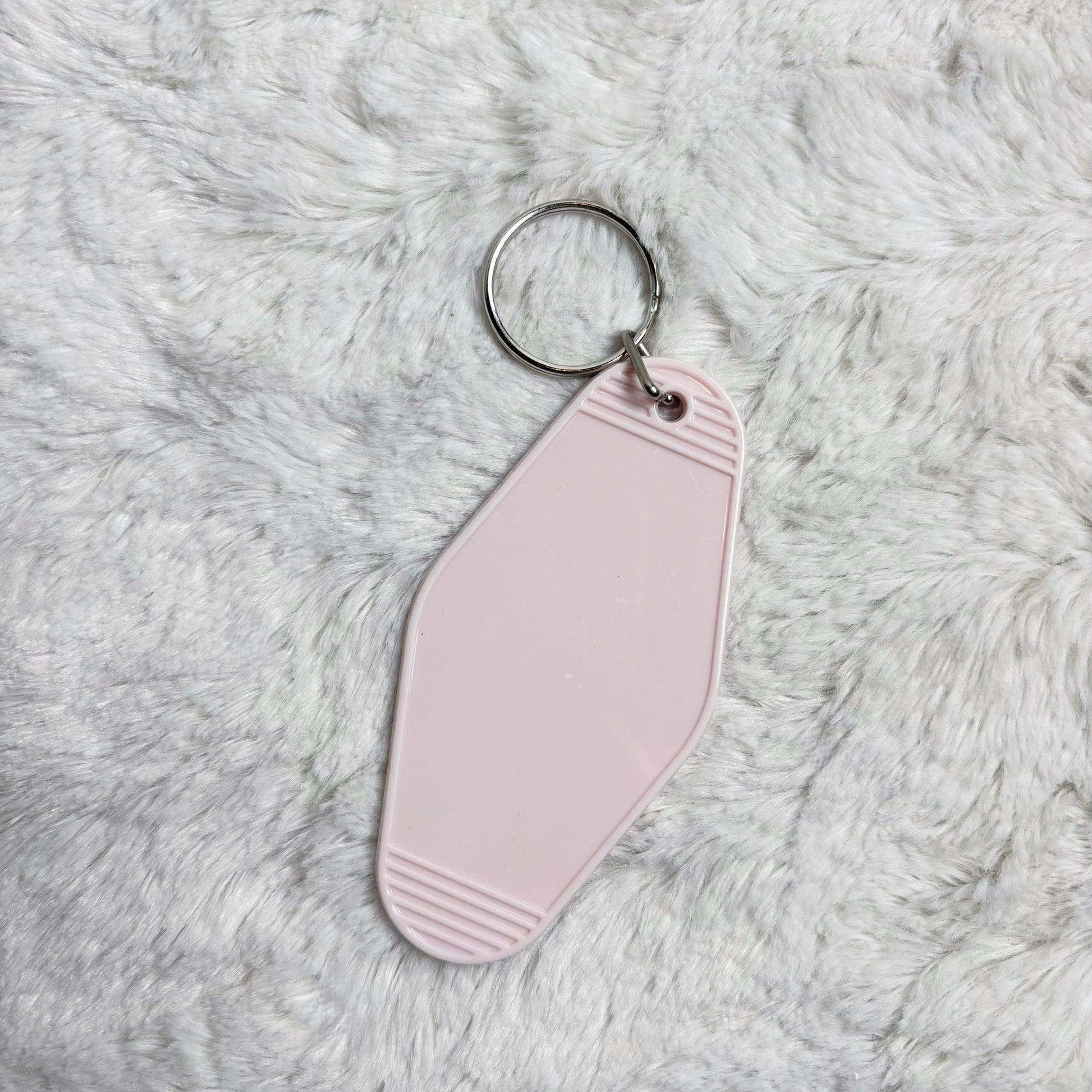 Pink keychain on a fluffy gray surface