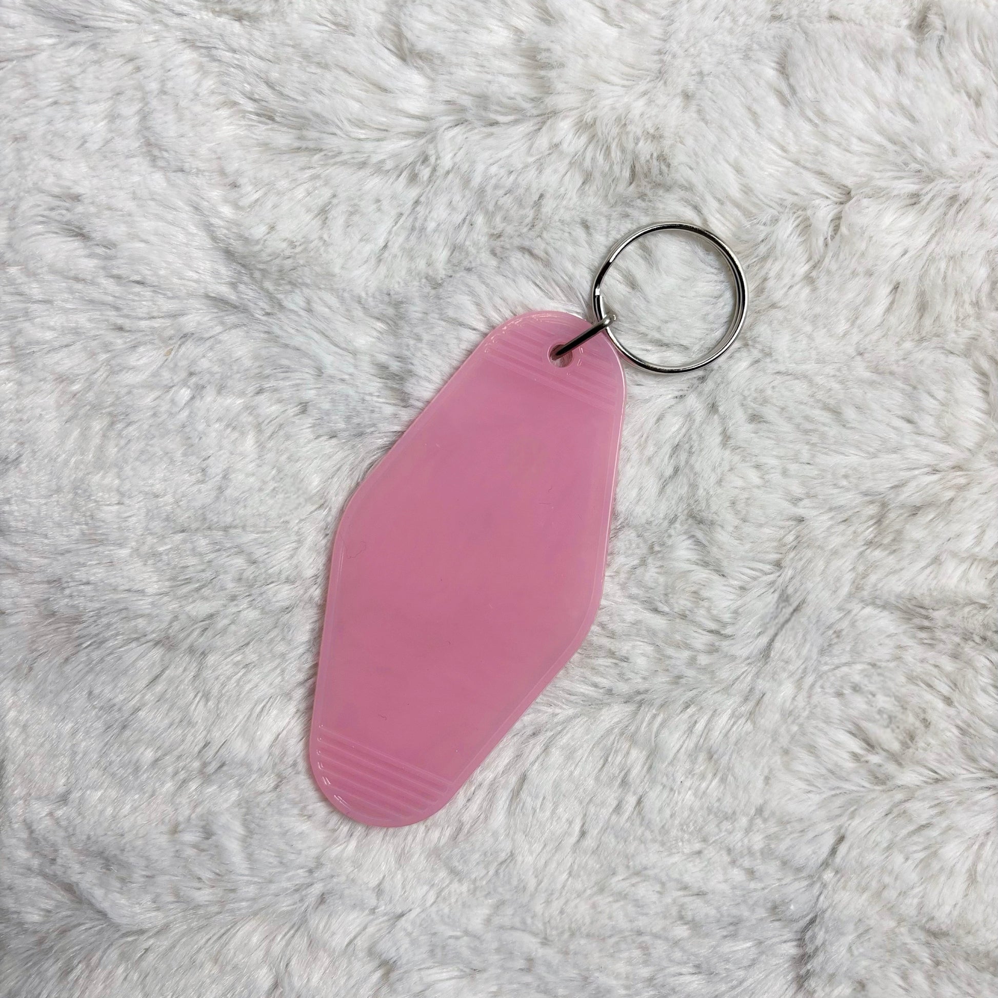 Pink keychain on a gray fluffy background