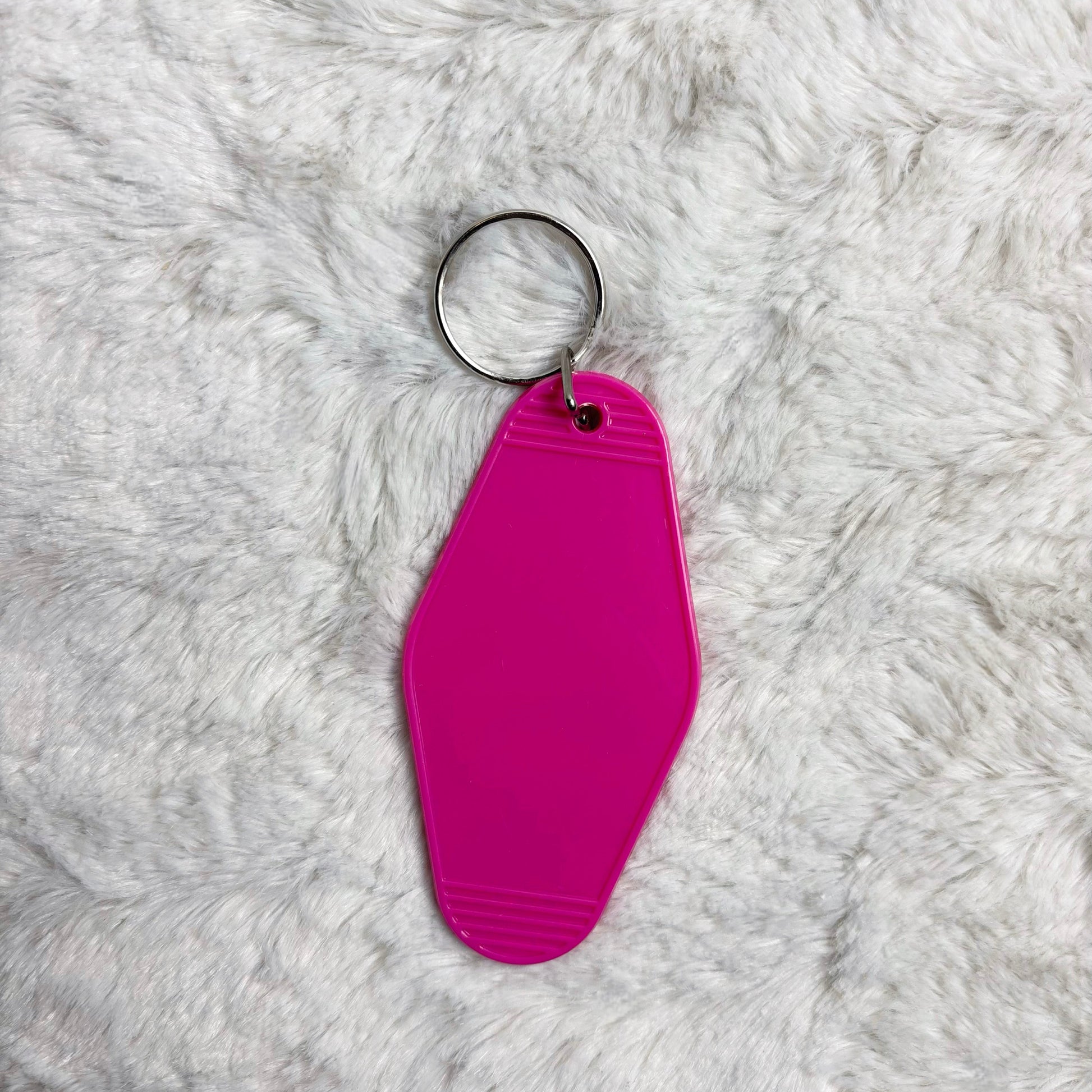 Pink keychain on a gray fluffy surface