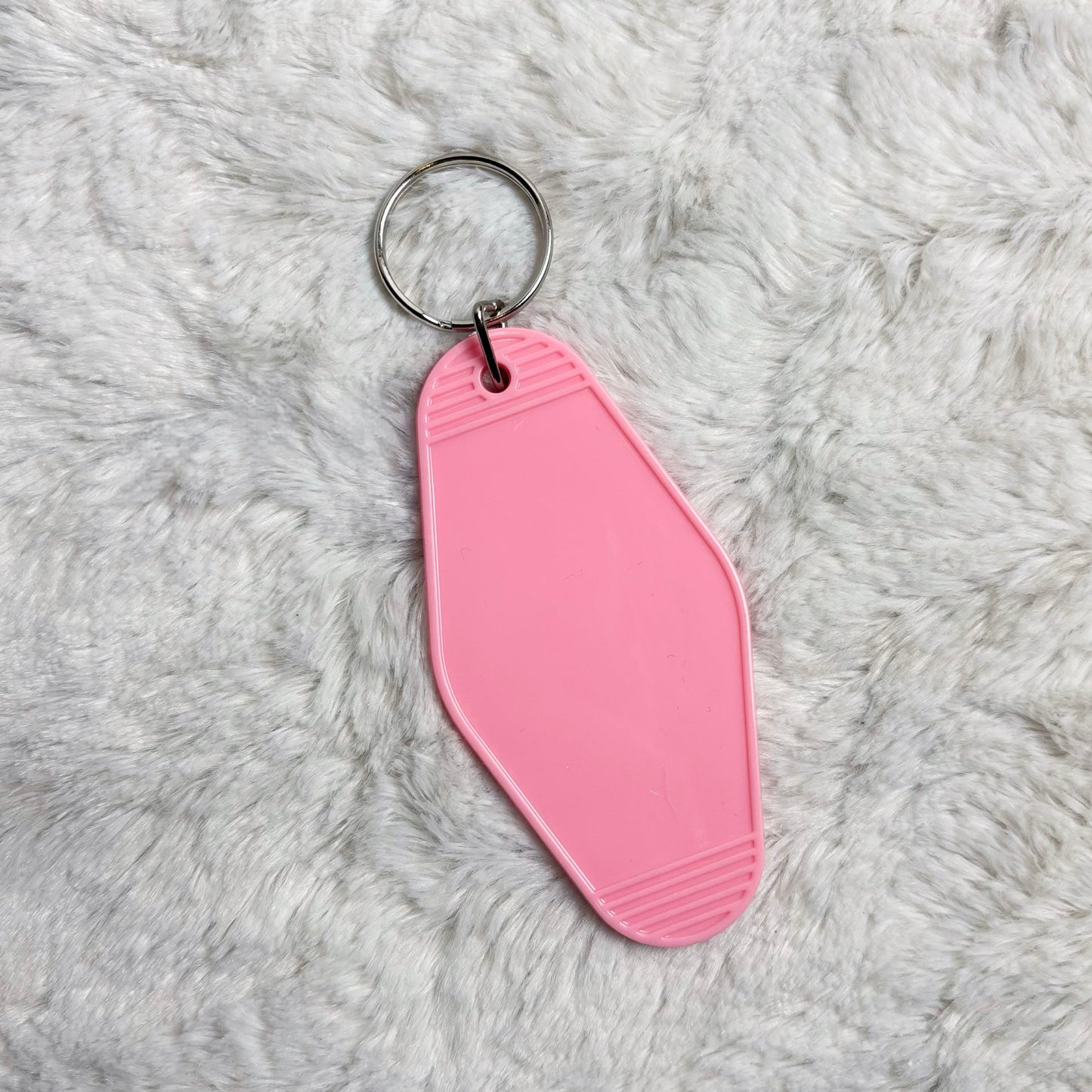 Pink keychain on a gray textured surface