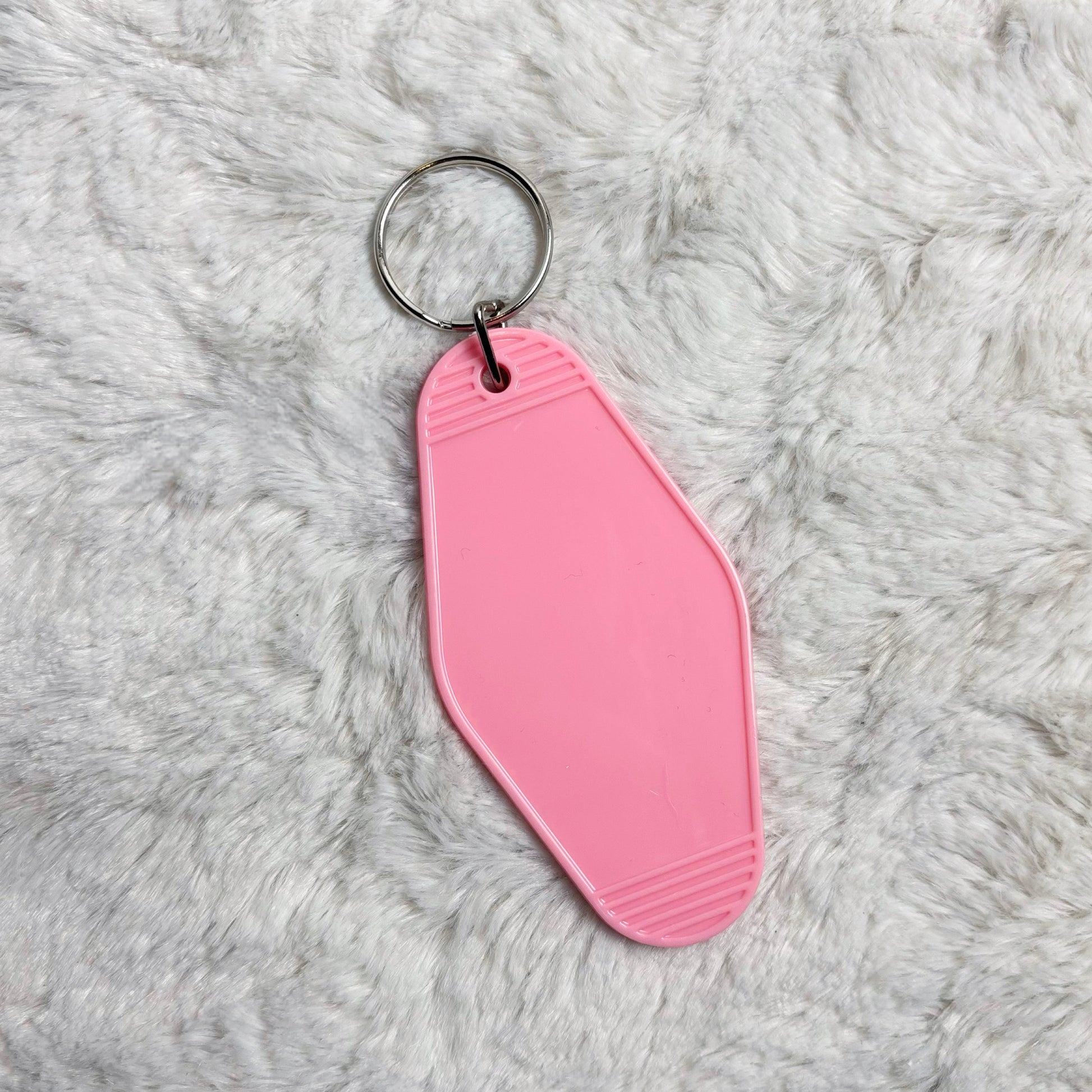 Pink keychain on a gray textured surface