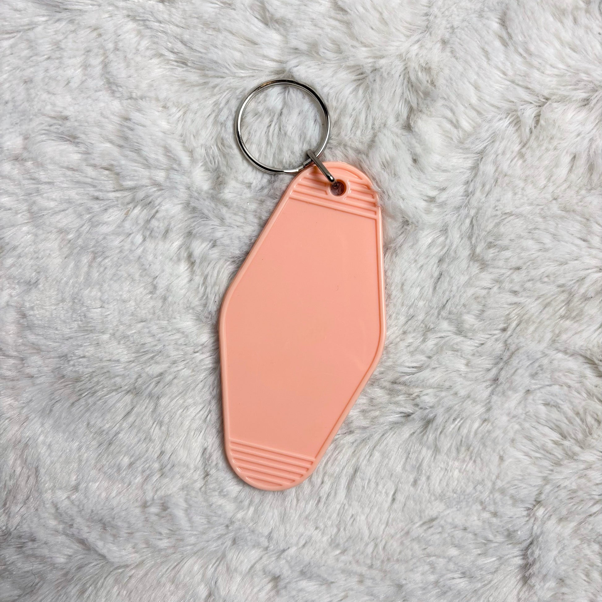 Pink keychain on a gray fluffy surface