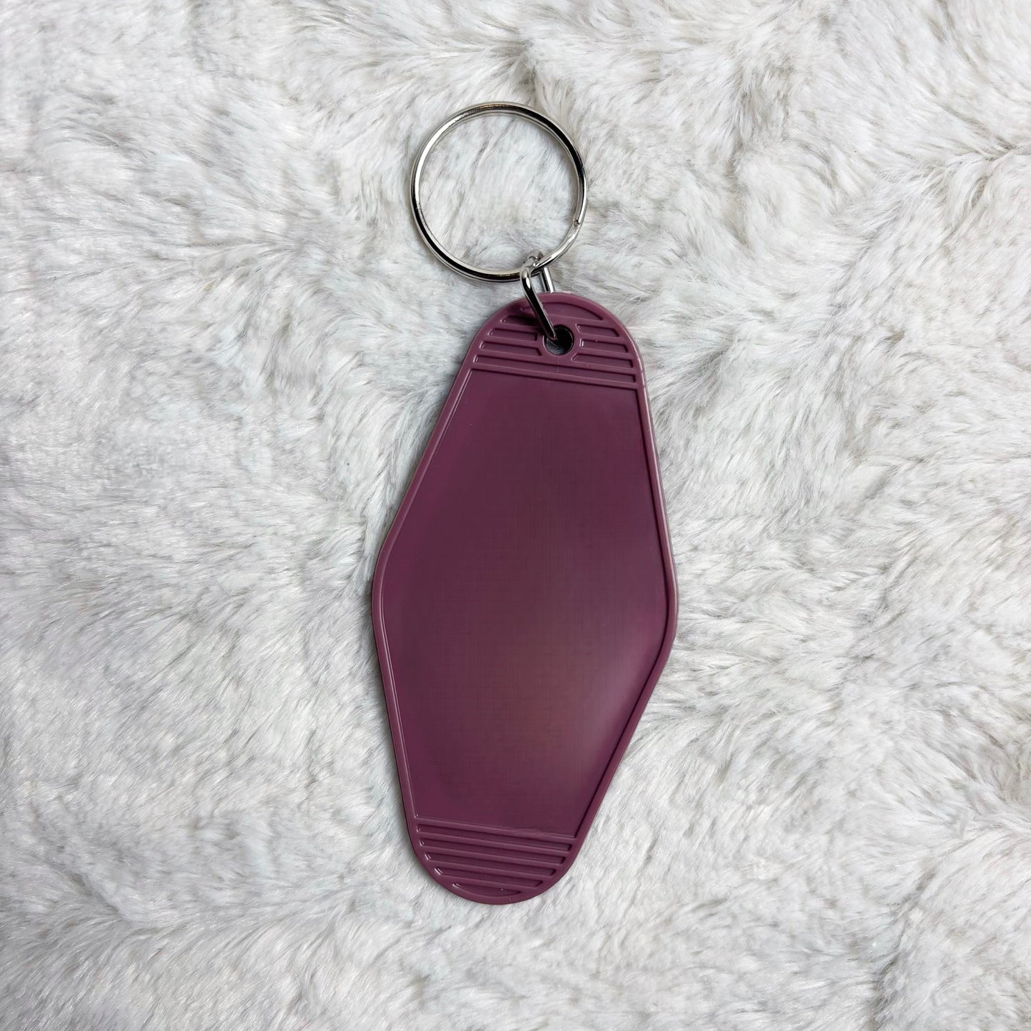 Purple keychain tag on a white fluffy surface