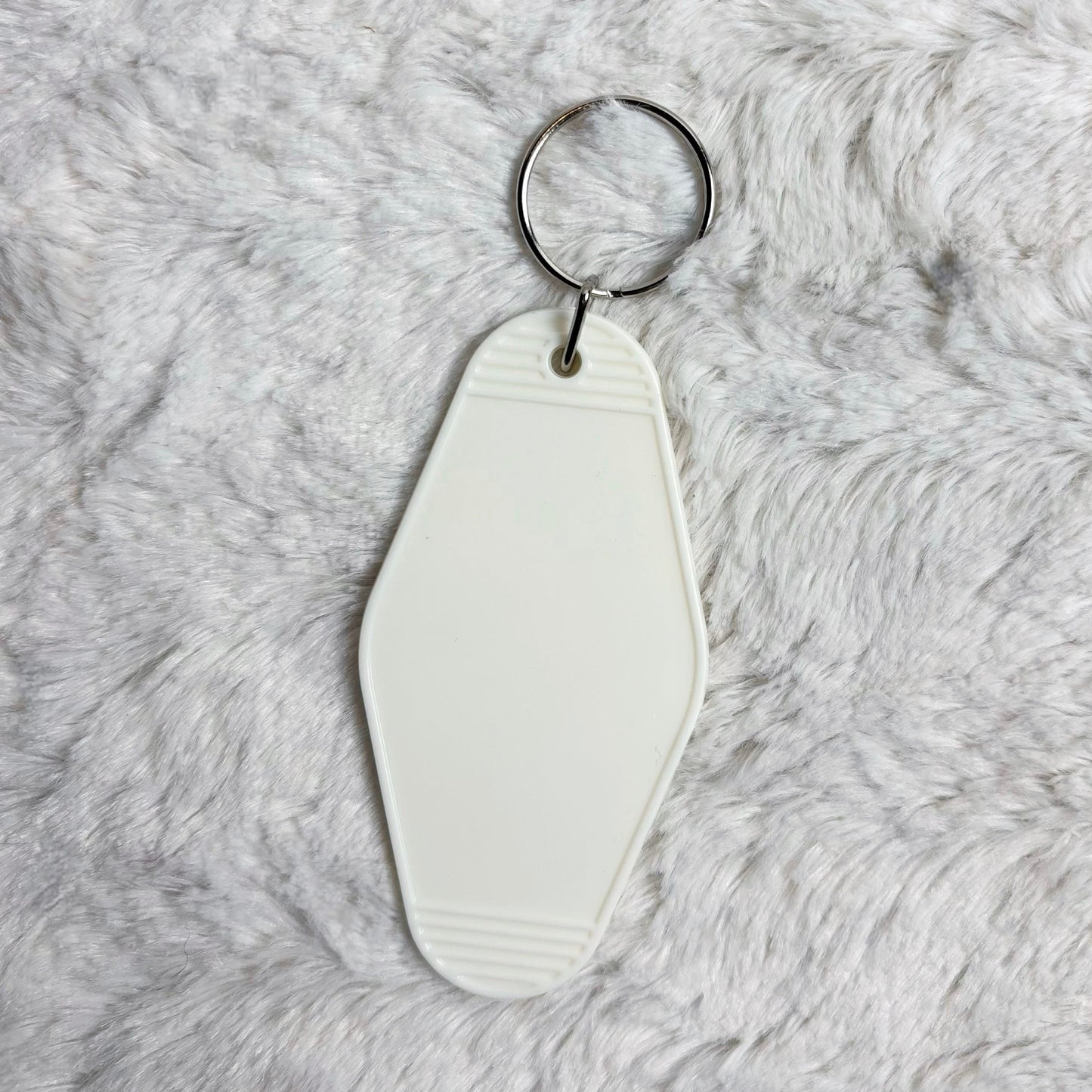 White keychain on a gray fur surface