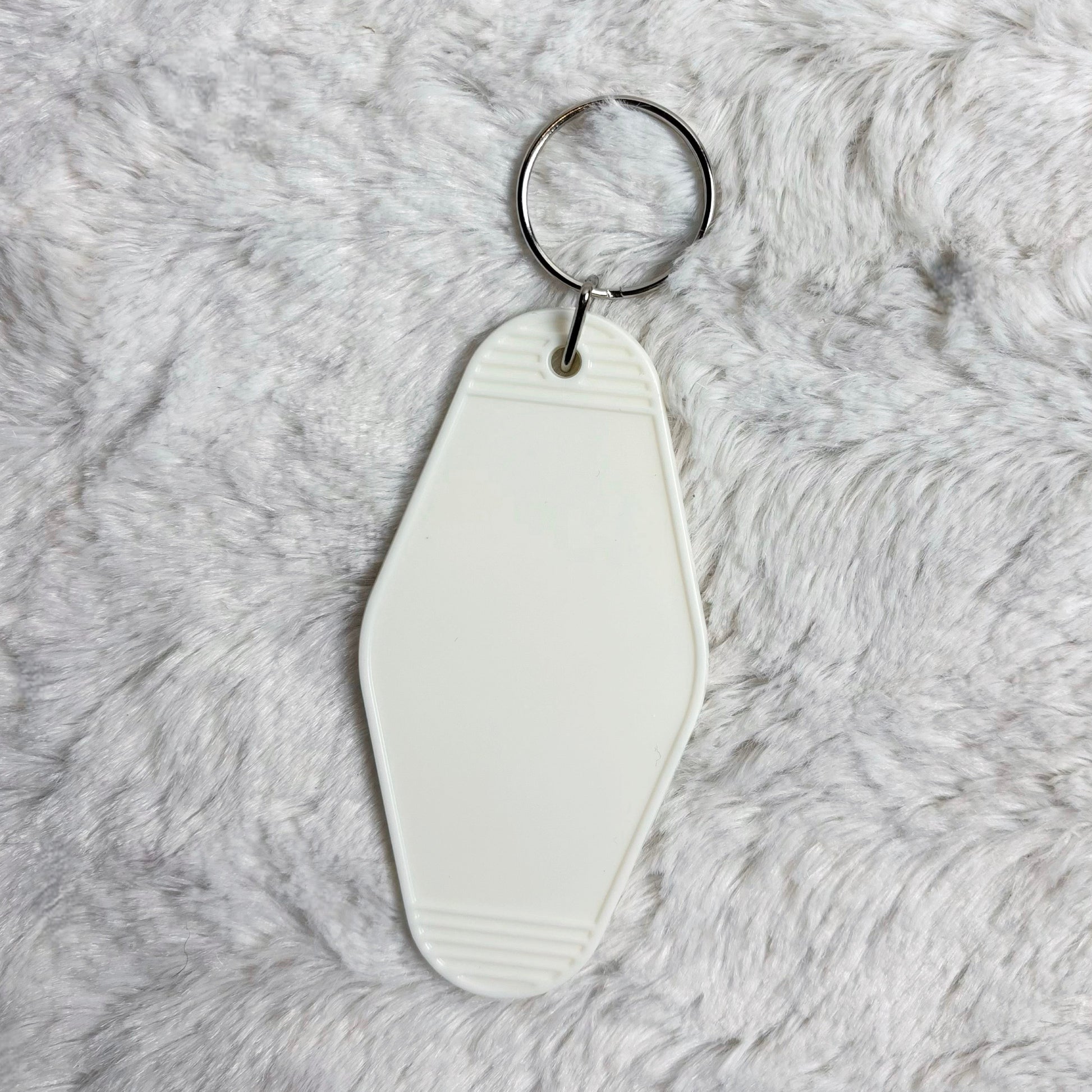 White keychain on a gray fur surface