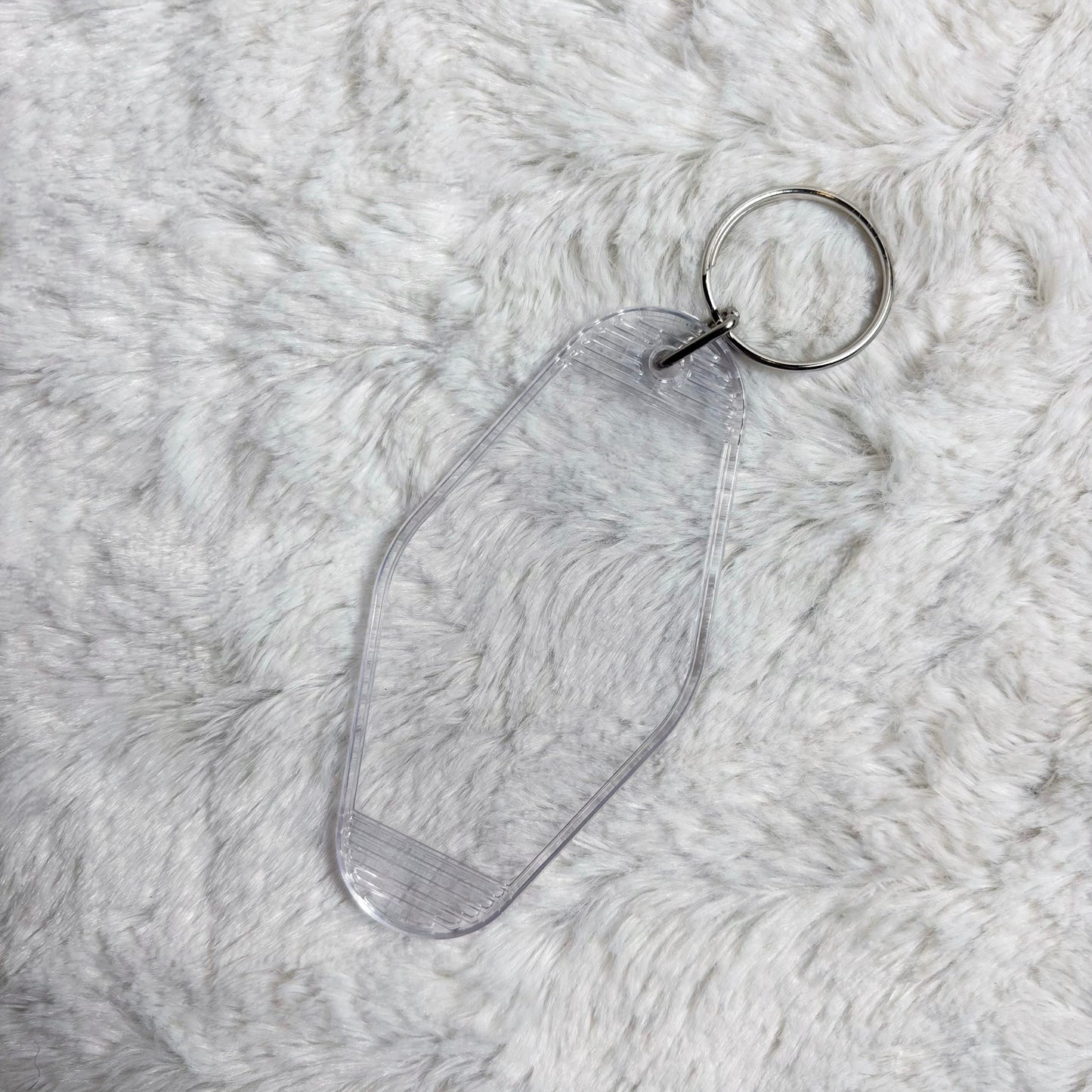 Clear acrylic keychain on a textured gray surface