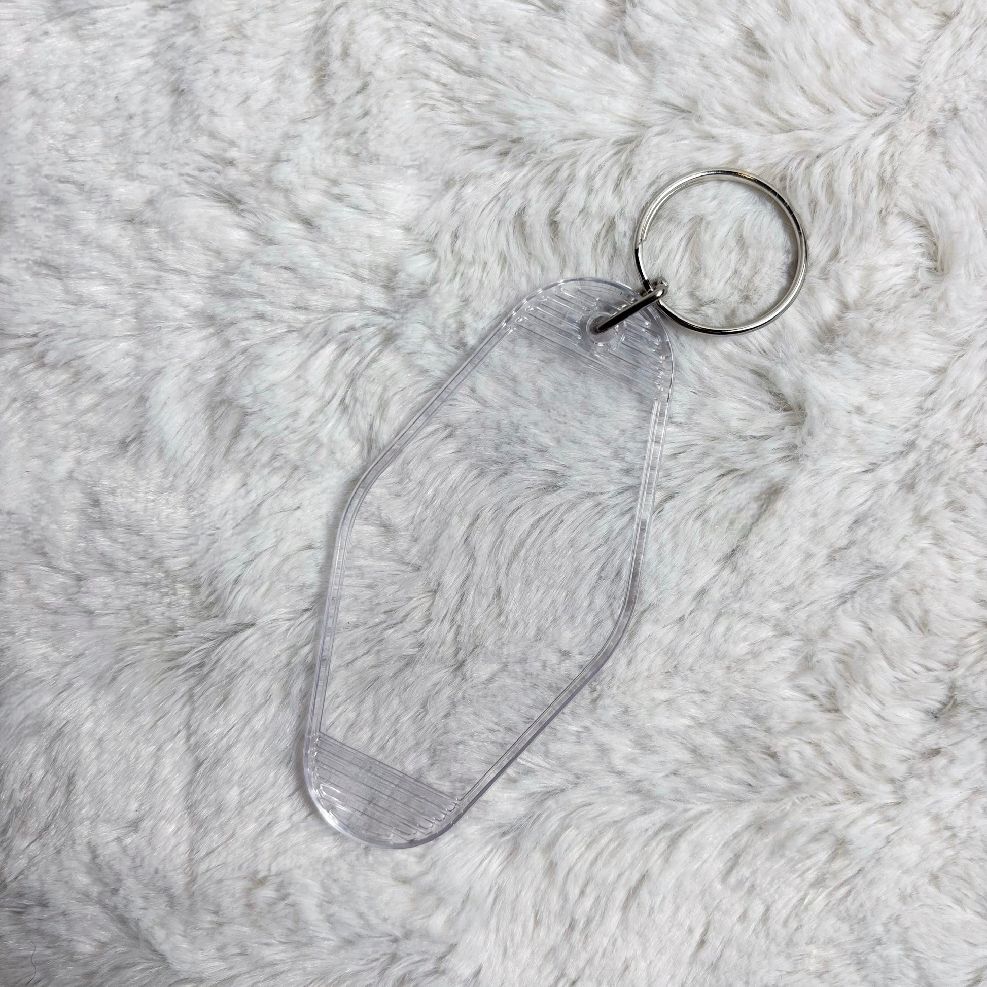 Clear acrylic keychain on a textured gray surface