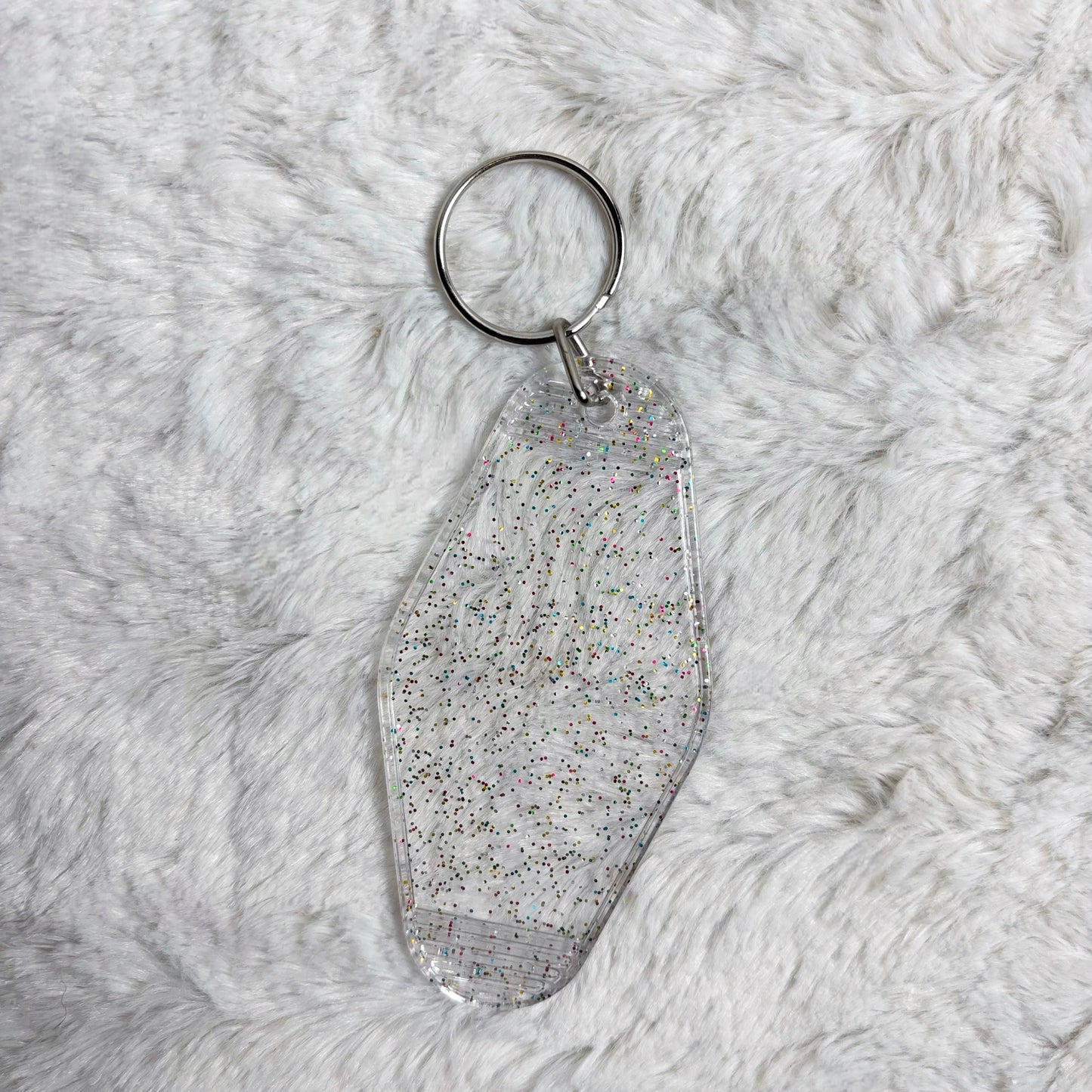 Keychain with glittery finish on a fluffy gray surface