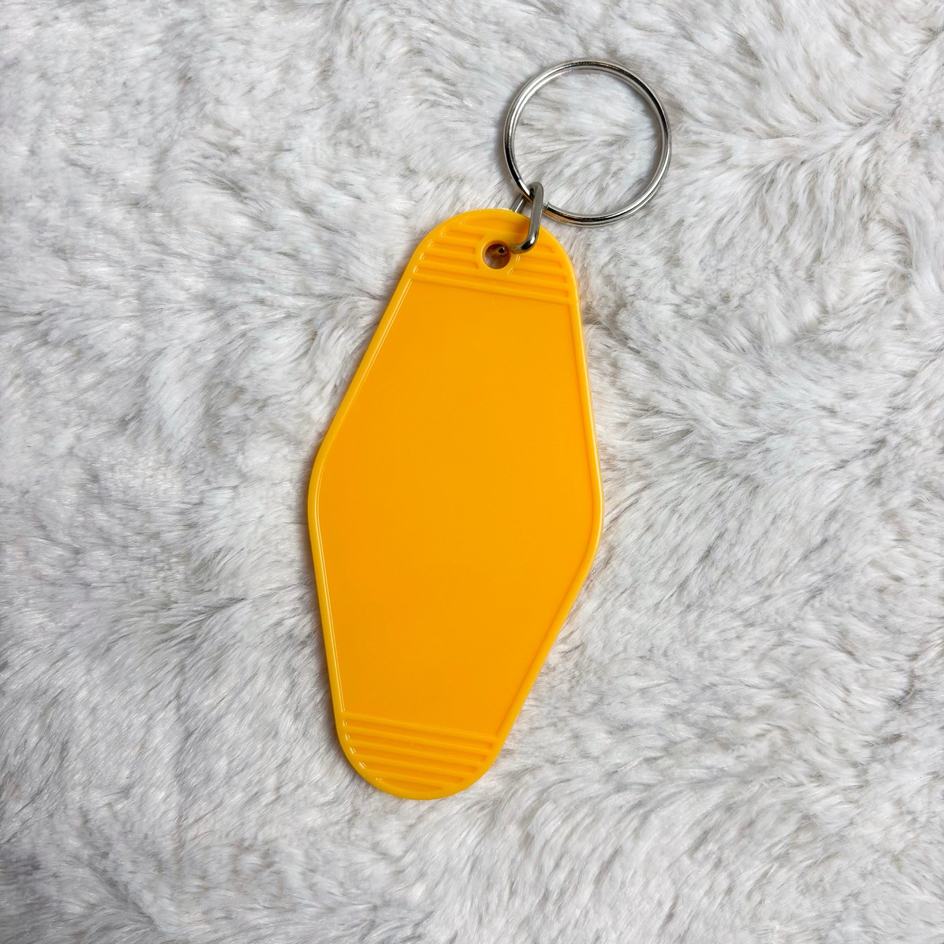 Yellow keychain tag on a gray textured background