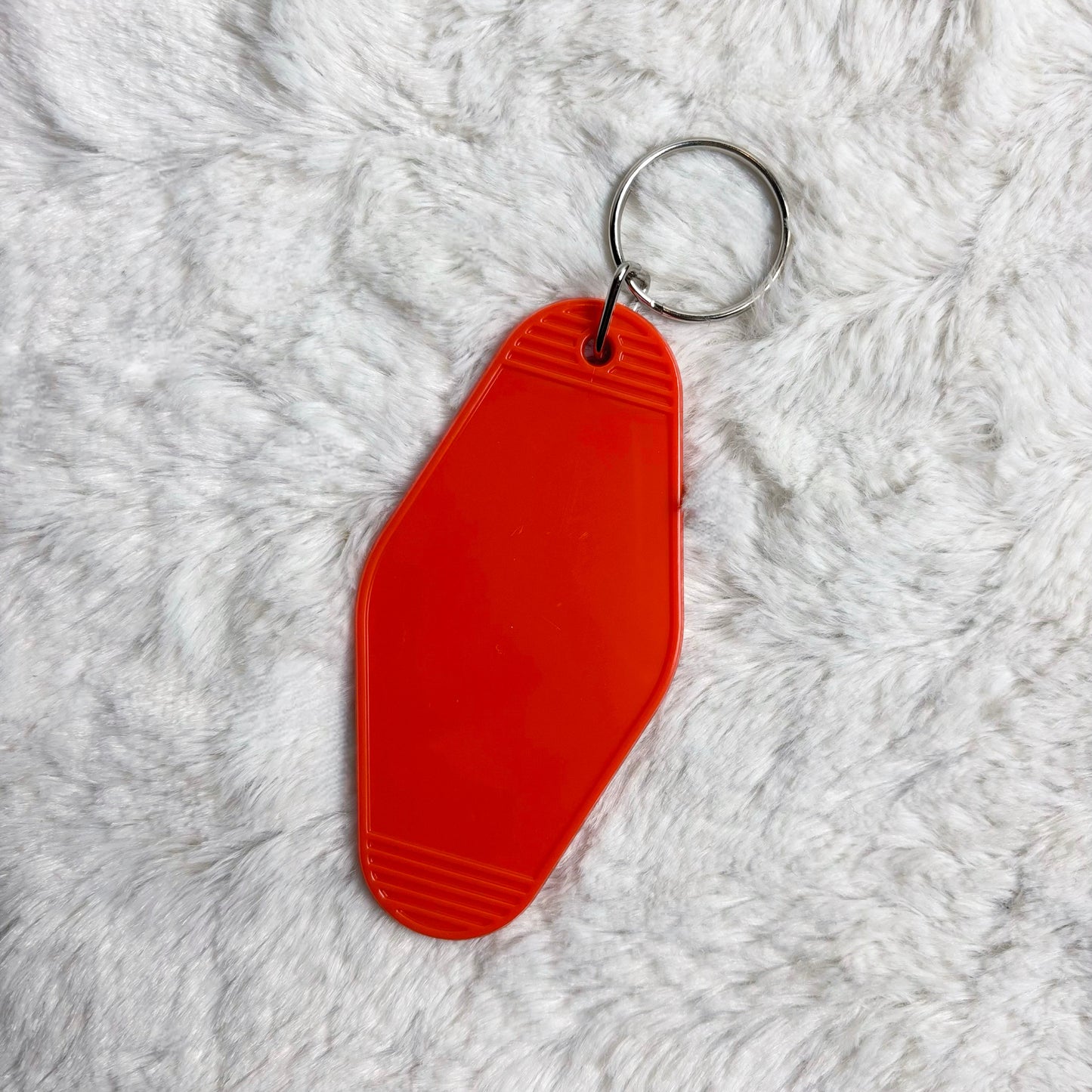 Orange keychain on a white fluffy surface