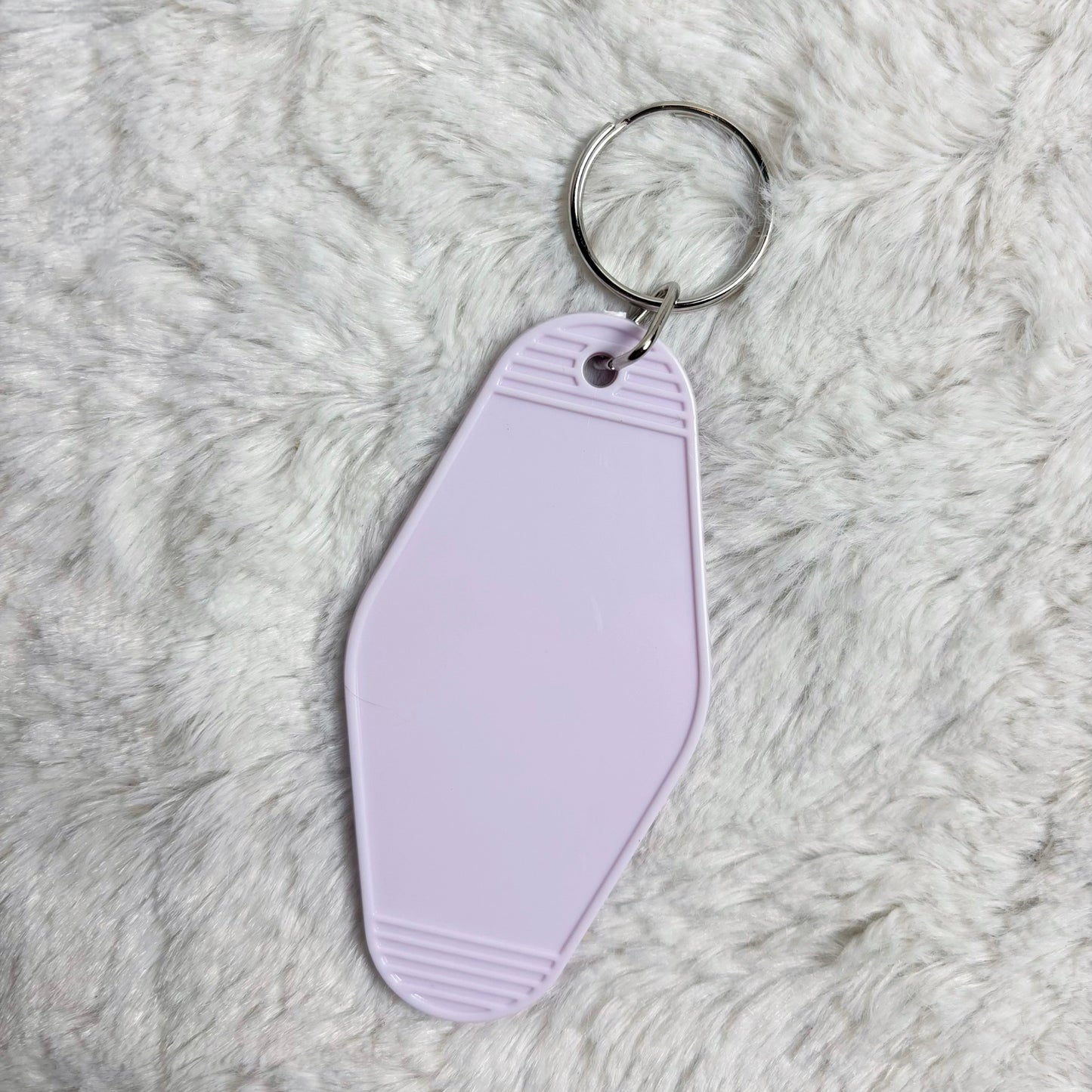 Purple keychain tag on a fluffy white surface