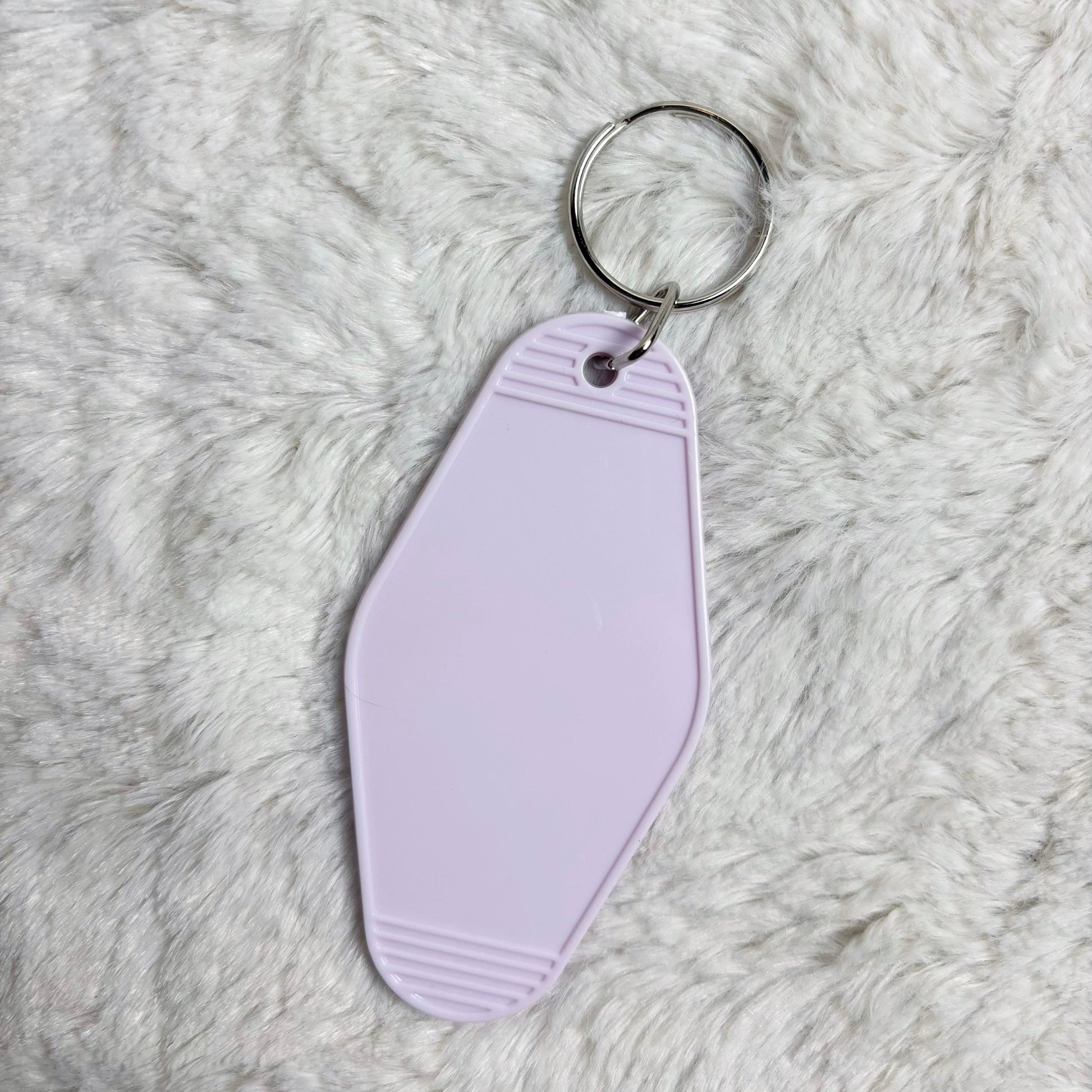 Purple keychain tag on a fluffy white surface