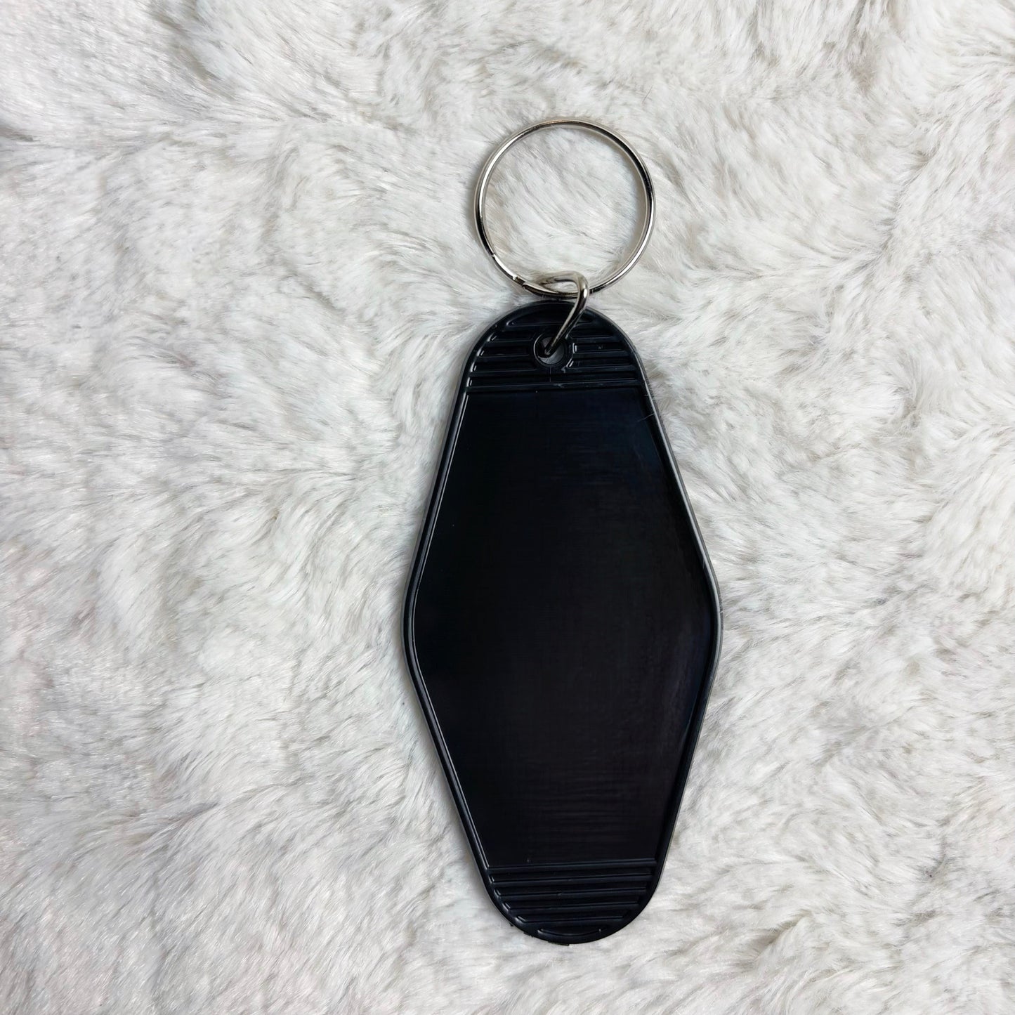 Black keychain on a white fluffy surface