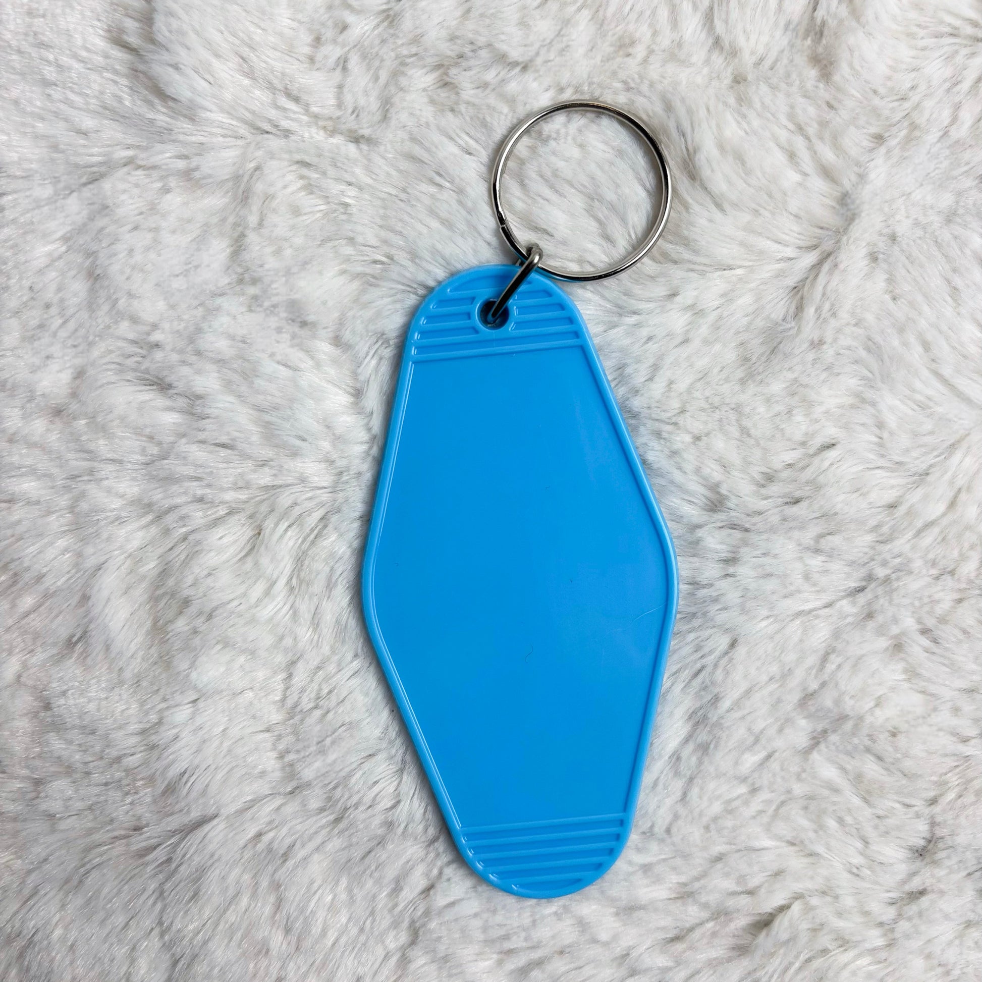 Blue keychain tag on a fluffy white surface
