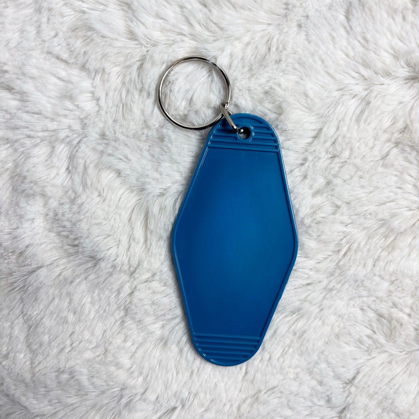 Blue keychain on a white fluffy surface
