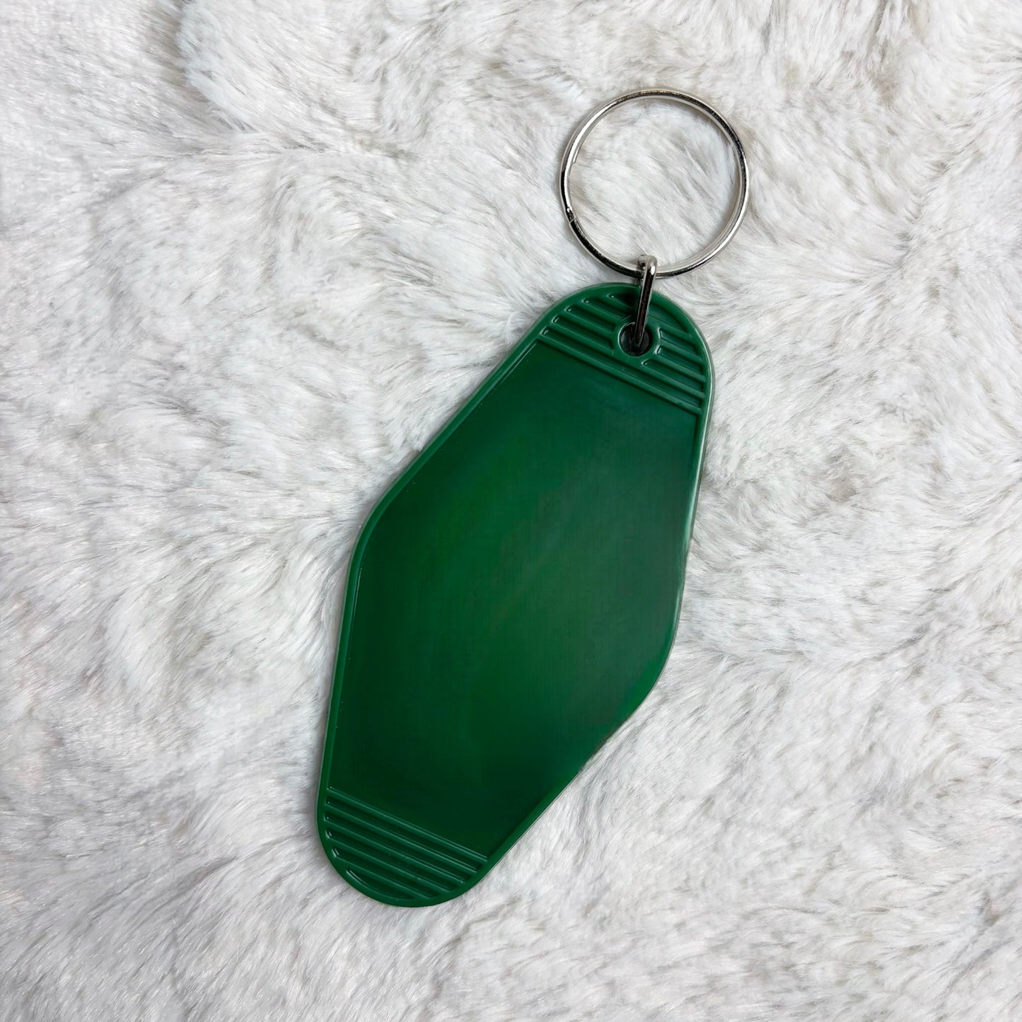 Green keychain on a white fluffy surface