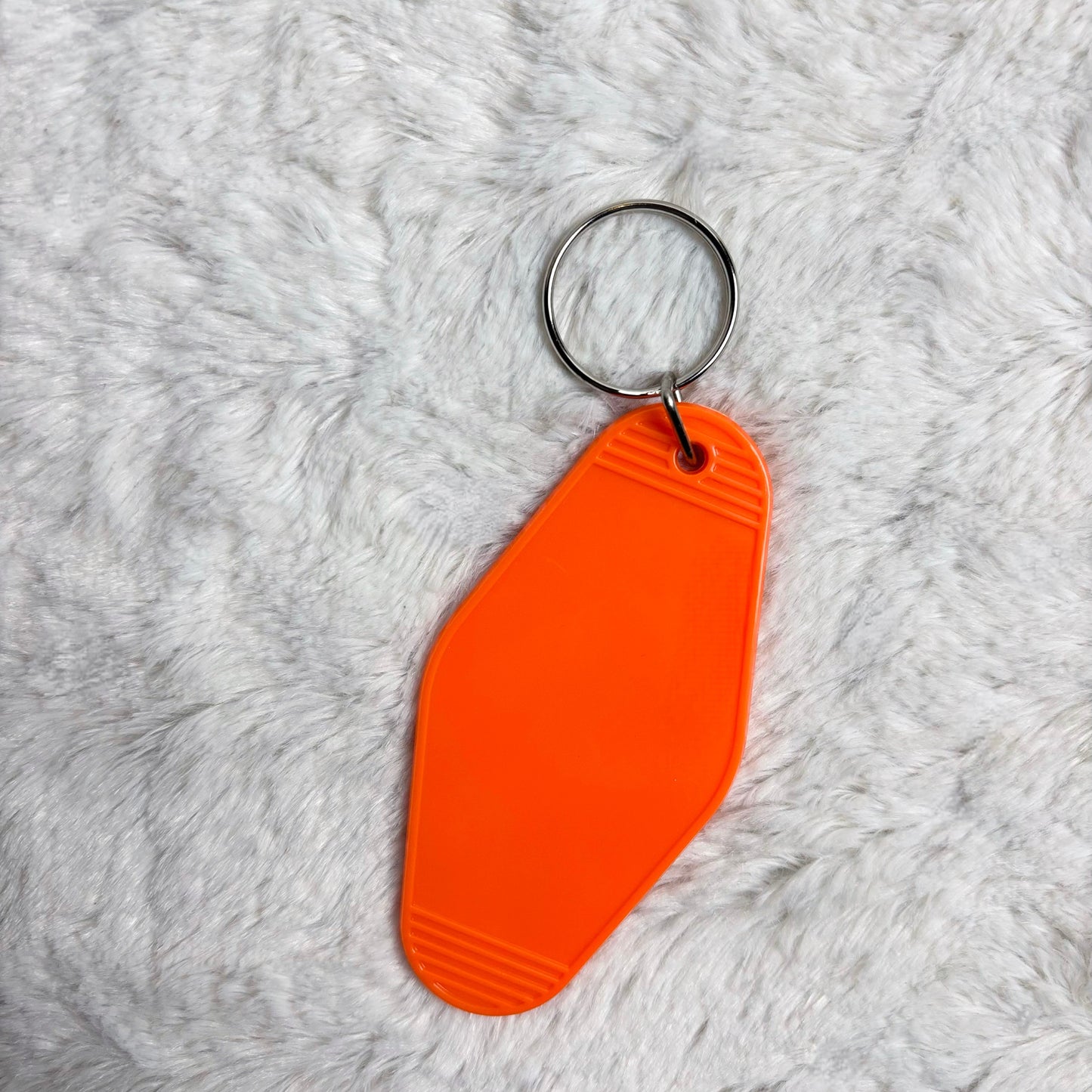 Orange keychain on a gray textured surface