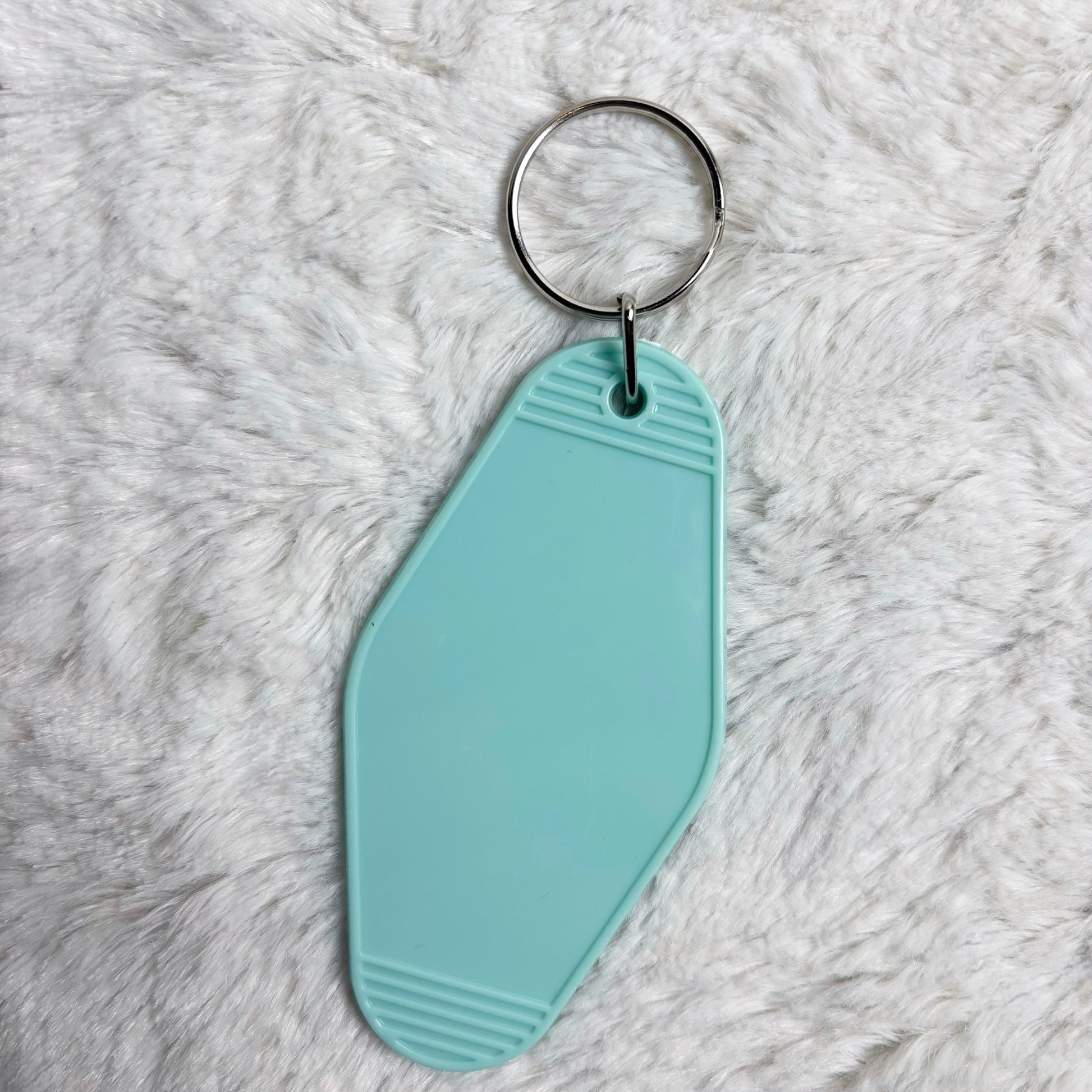 Light blue keychain tag on a fluffy white surface