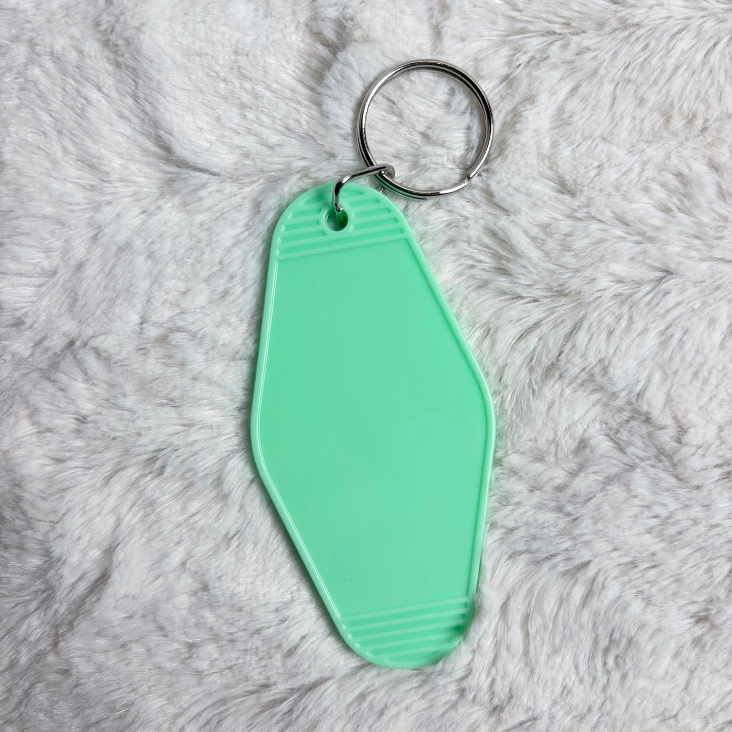 Mint green keychain on a gray fluffy background