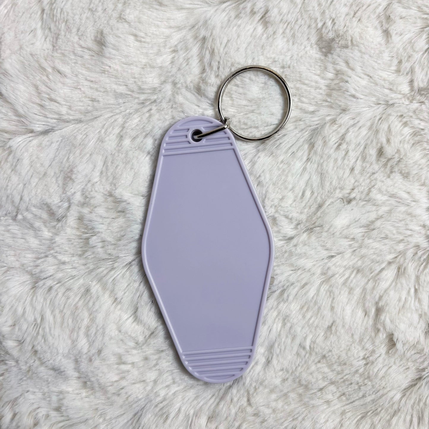 Lavender keychain tag on a fluffy gray surface