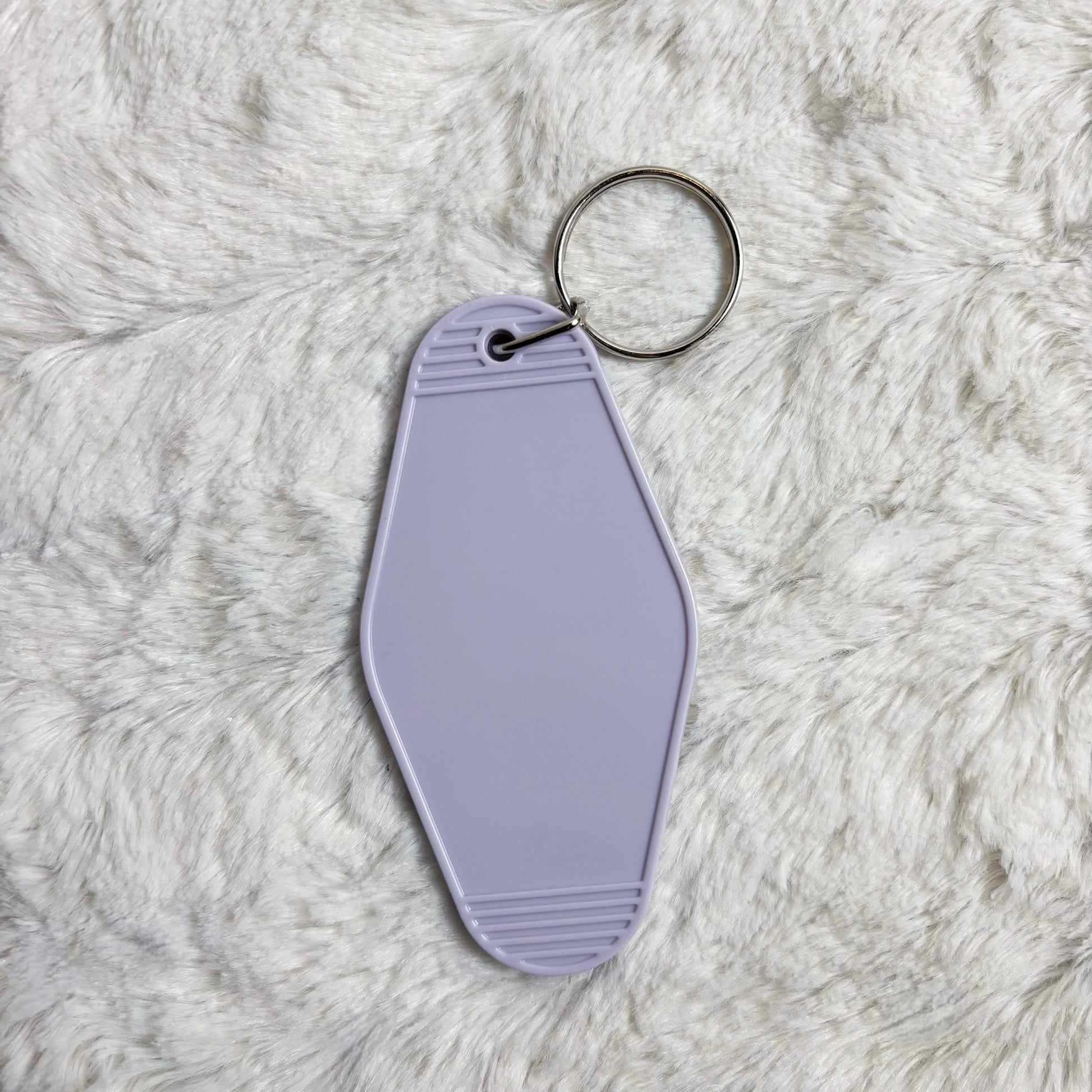 Lavender keychain tag on a fluffy gray surface