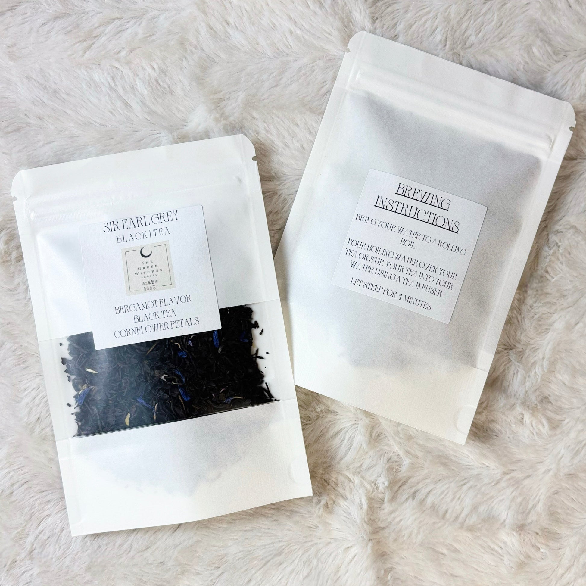 Two white packages with black text on a light gray fur surface