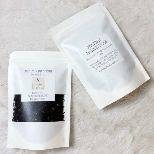 Two black tea packages on a light stone surface