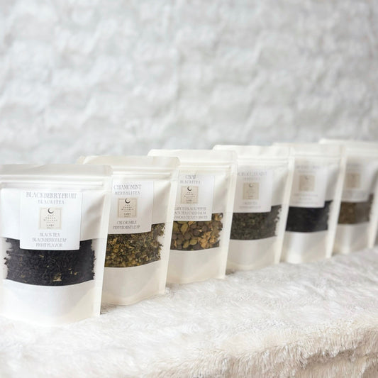 Row of tea packages on a textured white surface