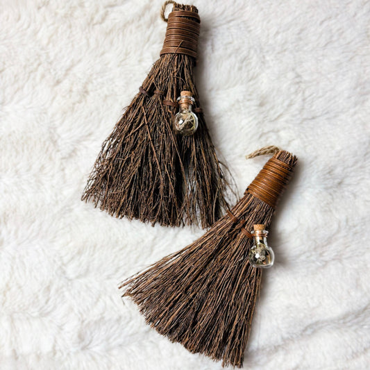 Two brown tassels with decorative elements on a textured white background