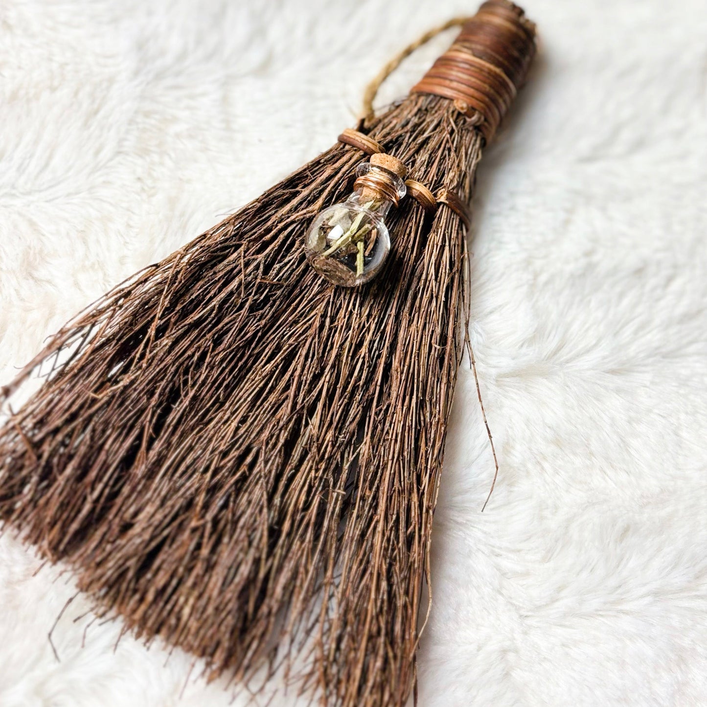 Close-up of a broom with tassels on a white background