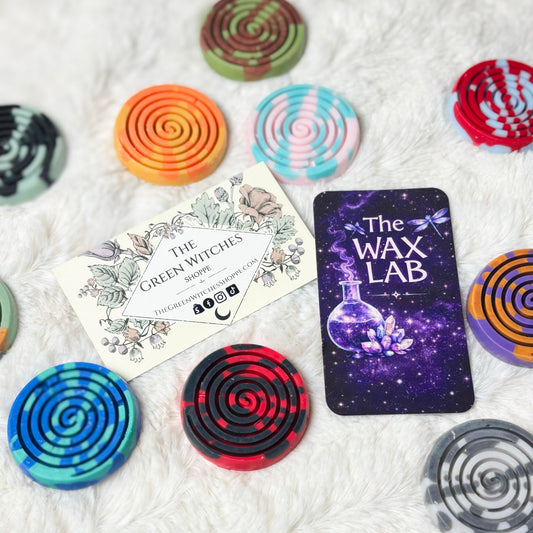 Colorful spiral-shaped products on a textured surface with 'The Wax Lab' branding.