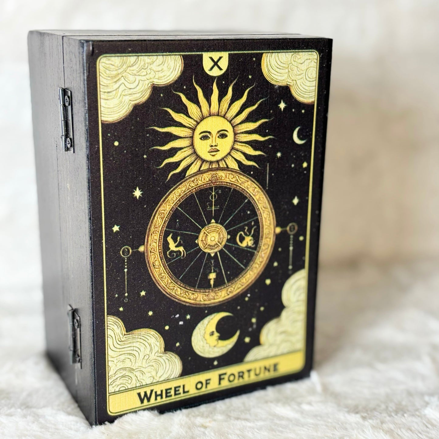 Decorative box with 'Wheel of Fortune' design on a soft white surface