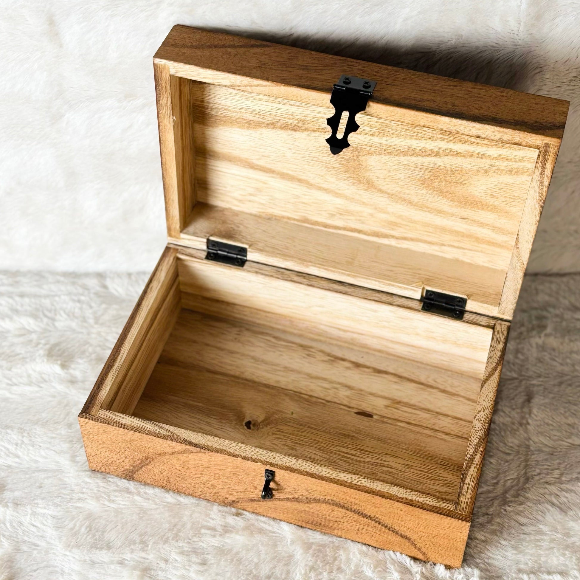 Wooden box with a latch on a textured white surface