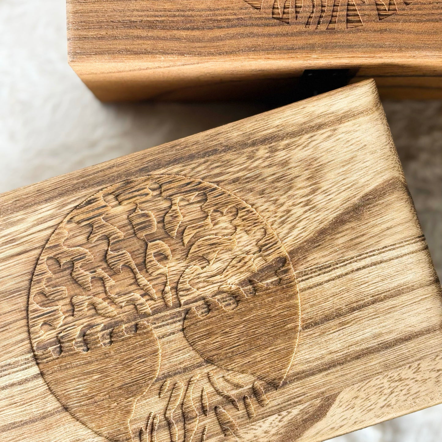 Wooden boxes with engraved design on a white surface