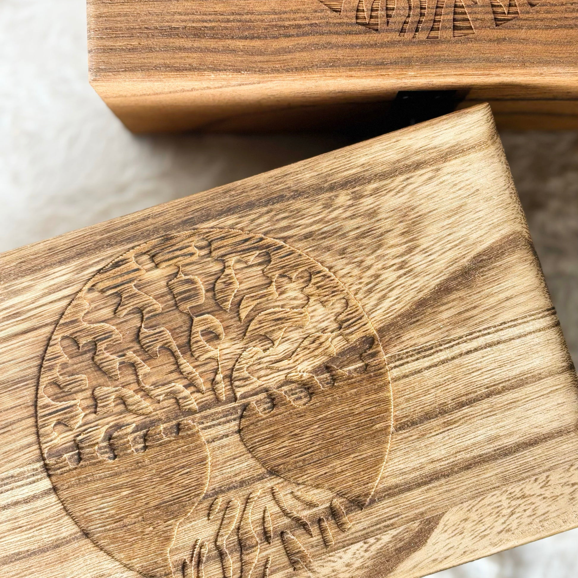 Wooden boxes with engraved design on a white surface