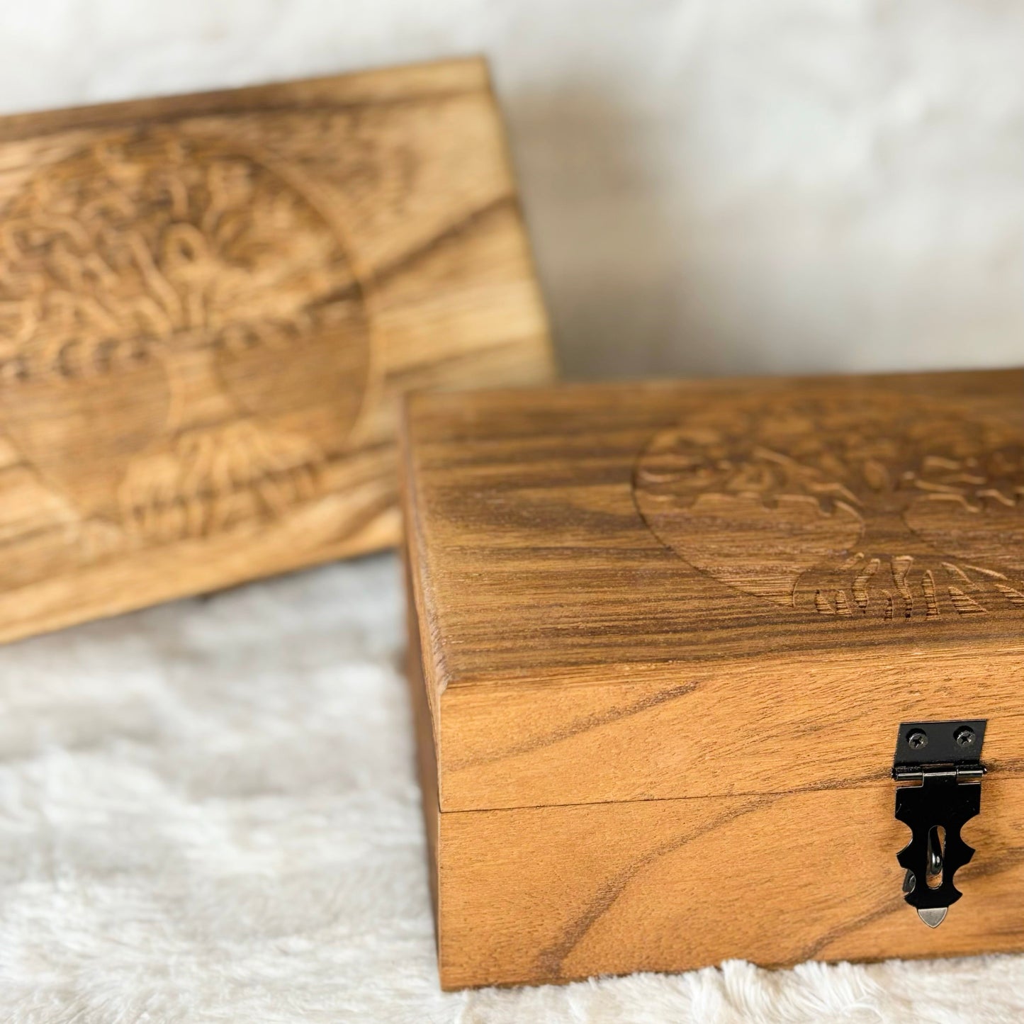 Wooden boxes with engraved designs on a white surface