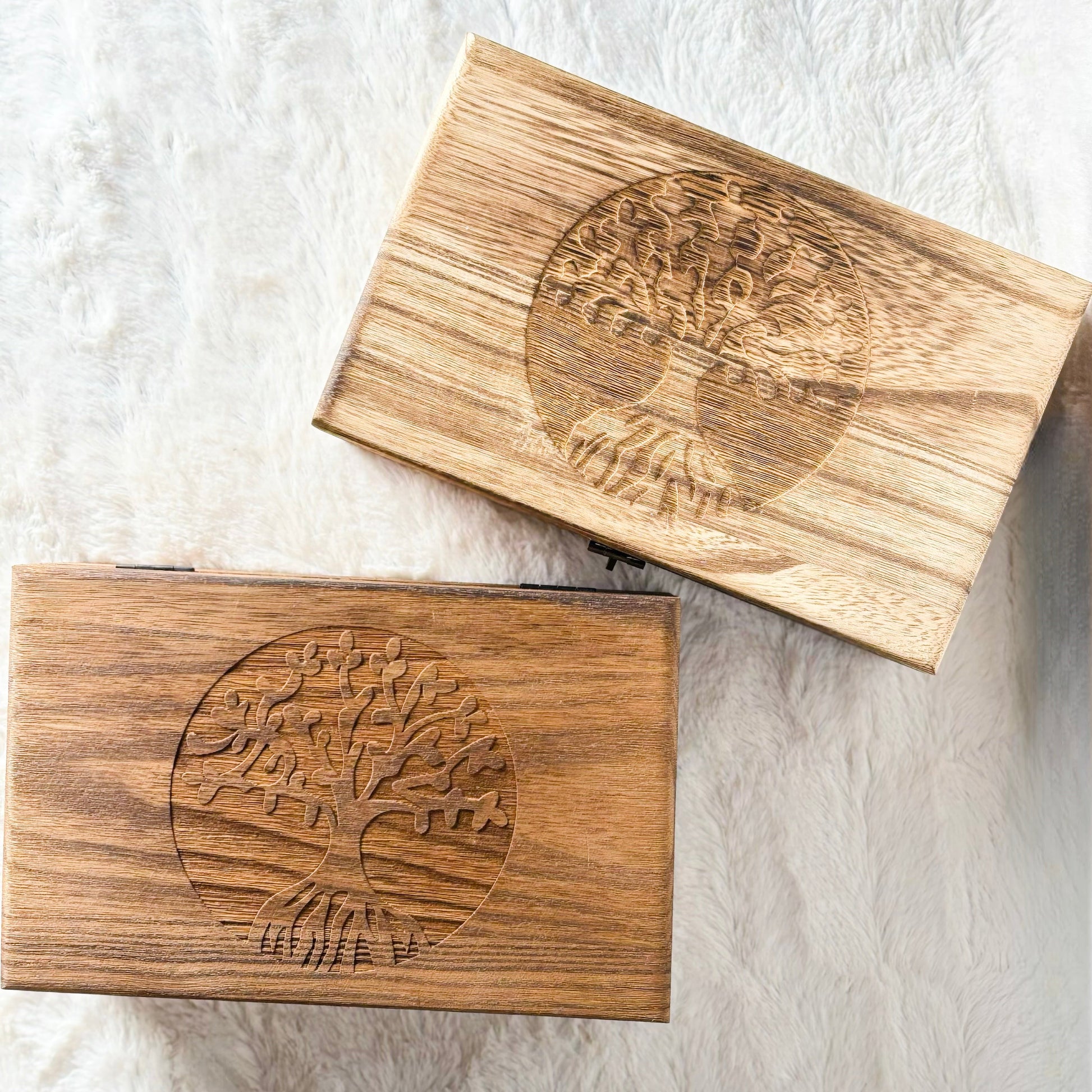 Two wooden blocks with engraved designs on a textured white surface