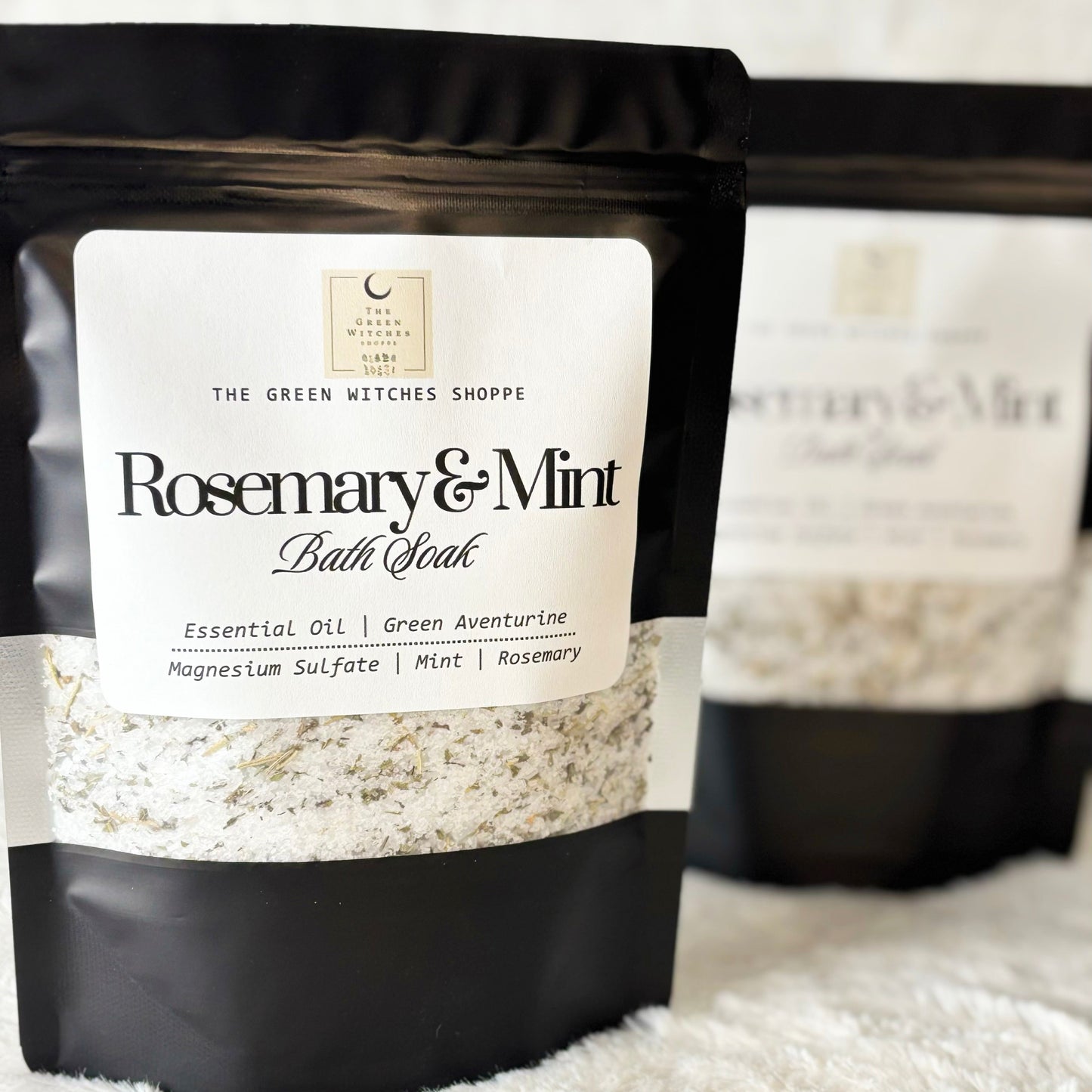Rosemary & Mint bath soak packaging with visible brand label on a textured surface.