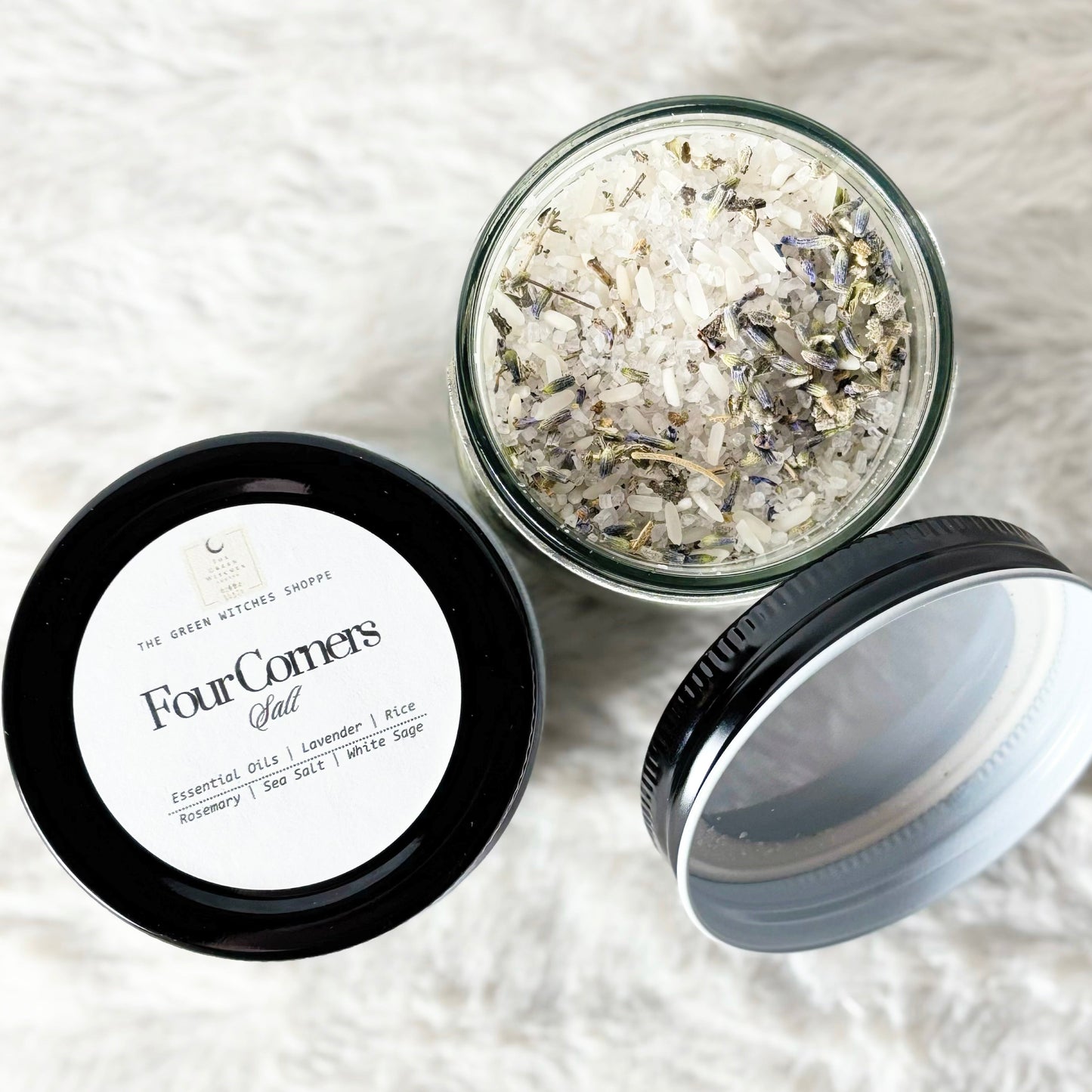 Glass jar with dried flowers and herbs on a white textured surface, labeled 'Four Corners'.