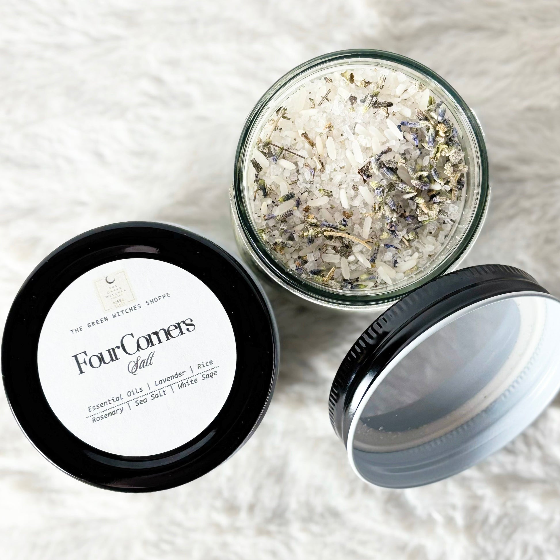 Glass jar with dried flowers and herbs on a white textured surface, labeled 'Four Corners'.